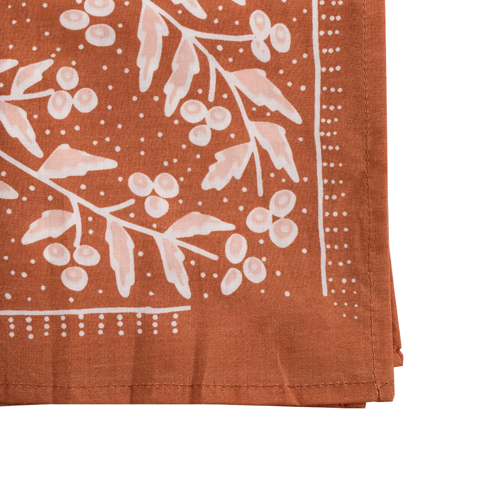 Folded fabric with floral pattern on a rust-colored background