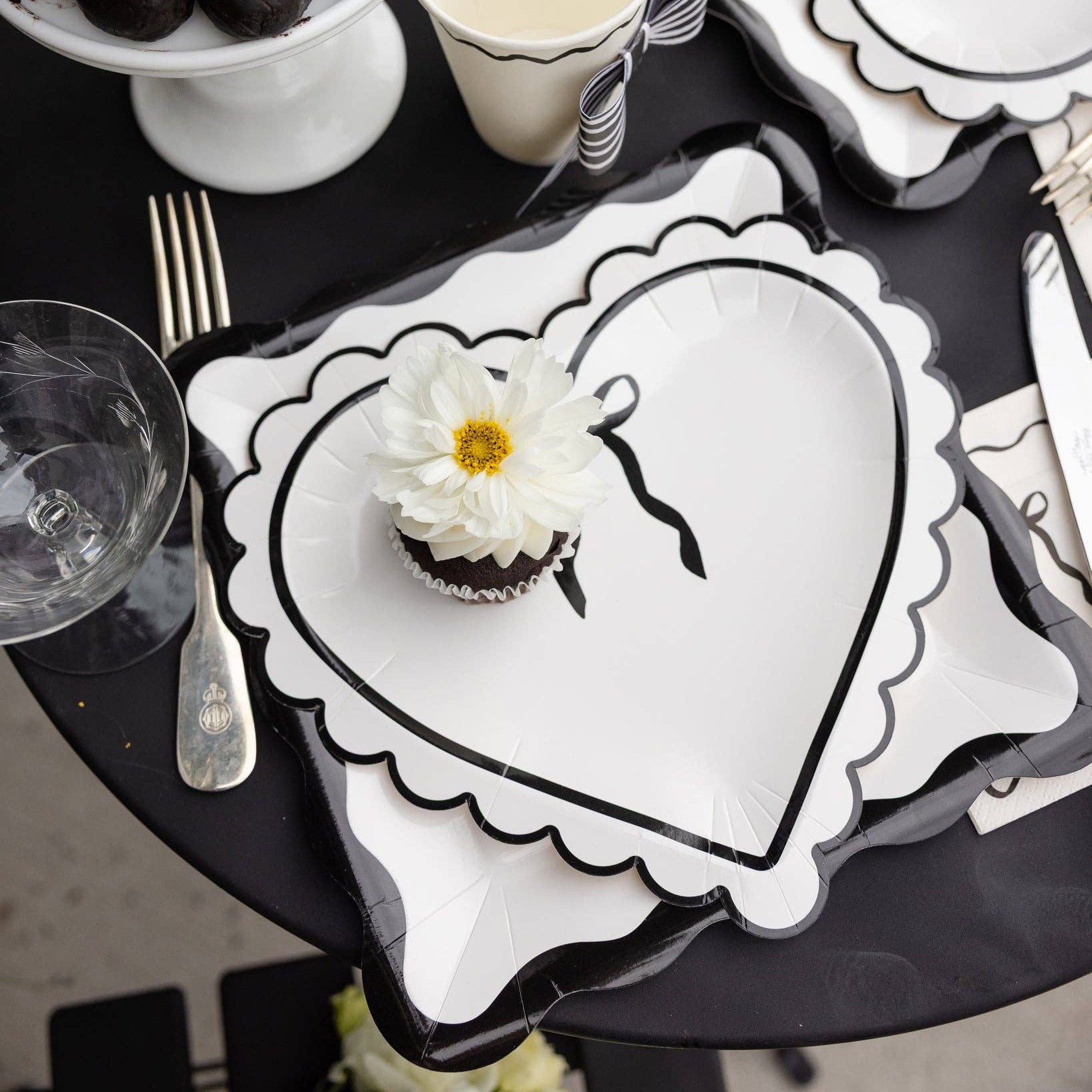 Elevate your Valentine's Day tablescape with this stunning 10" scalloped heart plate! Featuring an elegant cream and black color palette, this charming piece brings romantic sophistication to any celebration. Mix and match with coordinating pieces to build your dream Valentine's Day table.
Details:
Black and cream heart with bow design
Includes 8 scalloped heart shaped paper plates
Approx. 10" x 9"