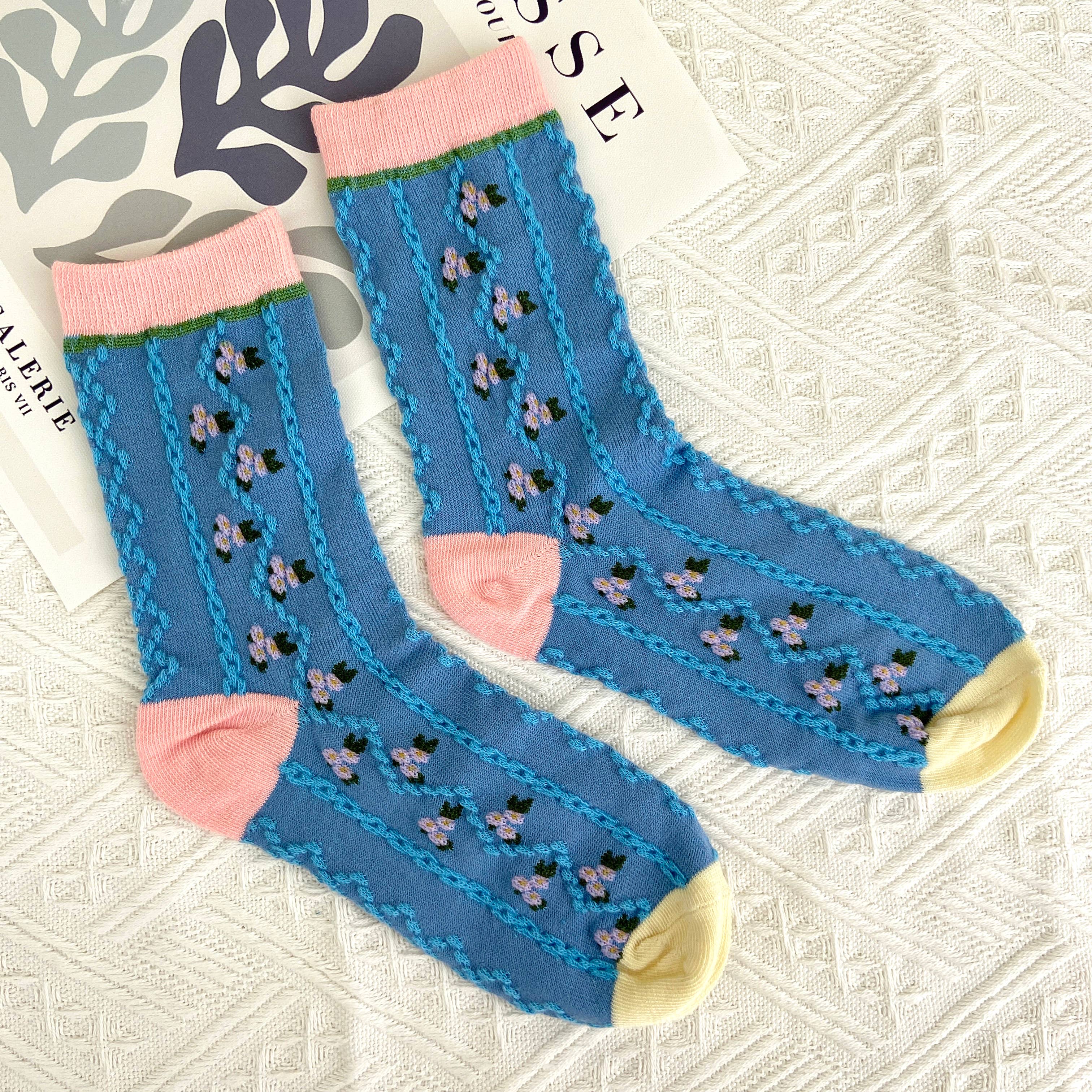 Step into comfort with these charming mid-calf socks featuring a delightful floral pattern in soft blue tones, accented with cheerful pink blooms. The vintage-inspired design brings a touch of timeless elegance to your everyday wardrobe, perfect for adding personality to any outfit. Whether you're dressing up or keeping it casual, these floral socks offer the cozy support you deserve while celebrating your unique style.