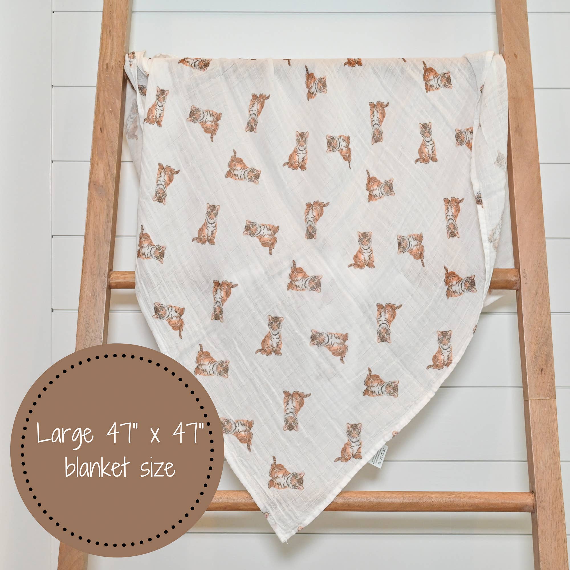 Baby blanket with animal pattern draped over a wooden ladder on a white background