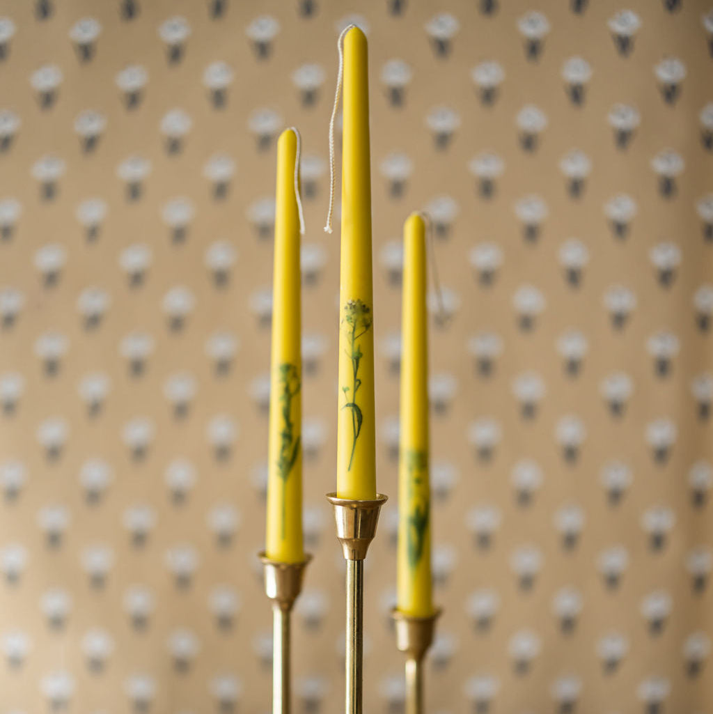 three floral inlaid taper candles in candlestick holders