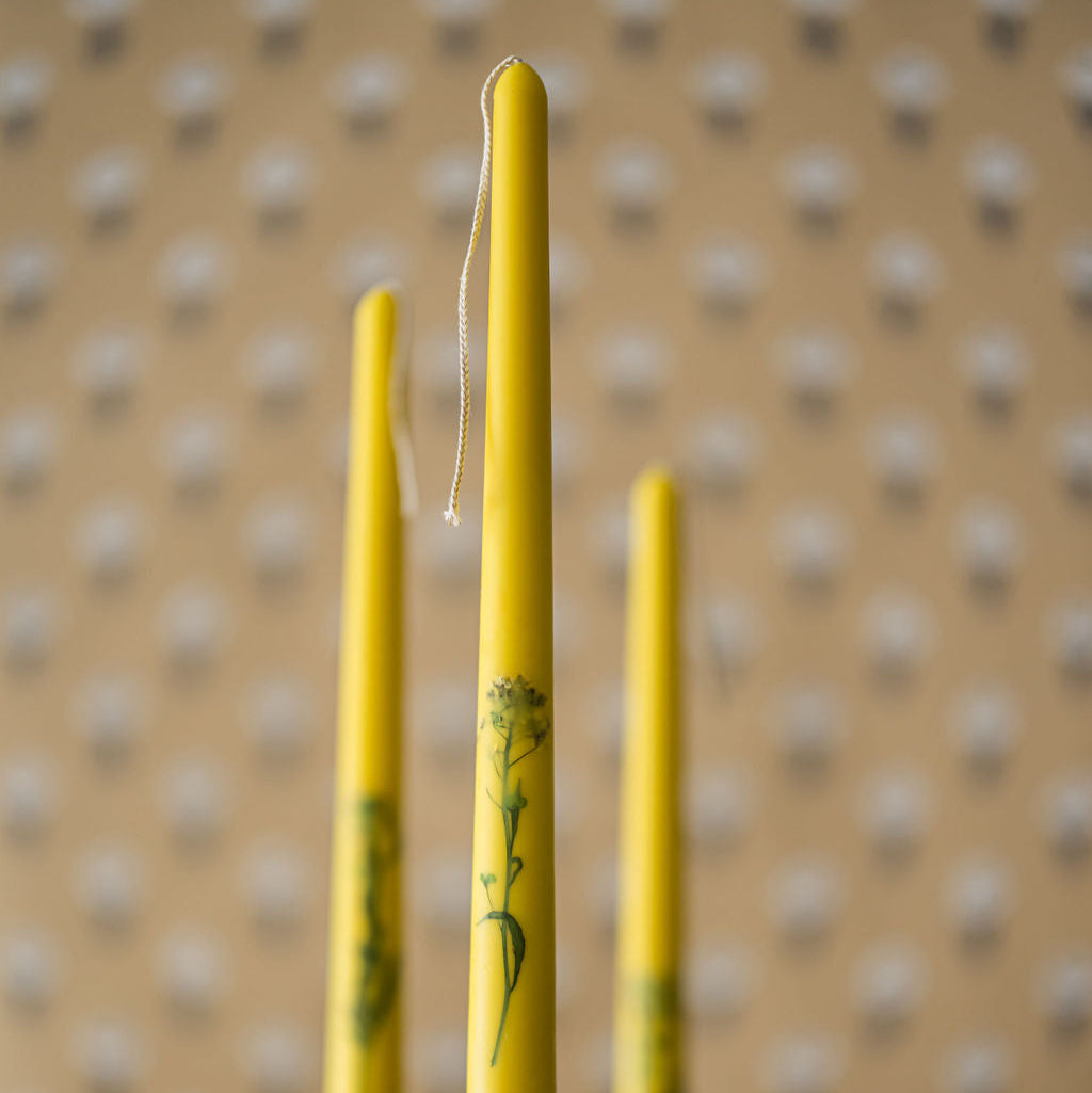 three floral inlaid taper candles in candlestick holders