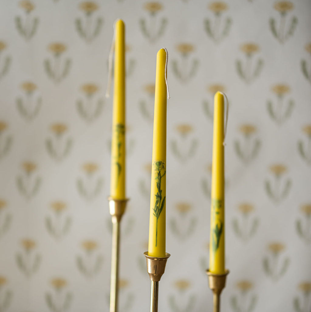 three floral inlaid taper candles in candlestick holders