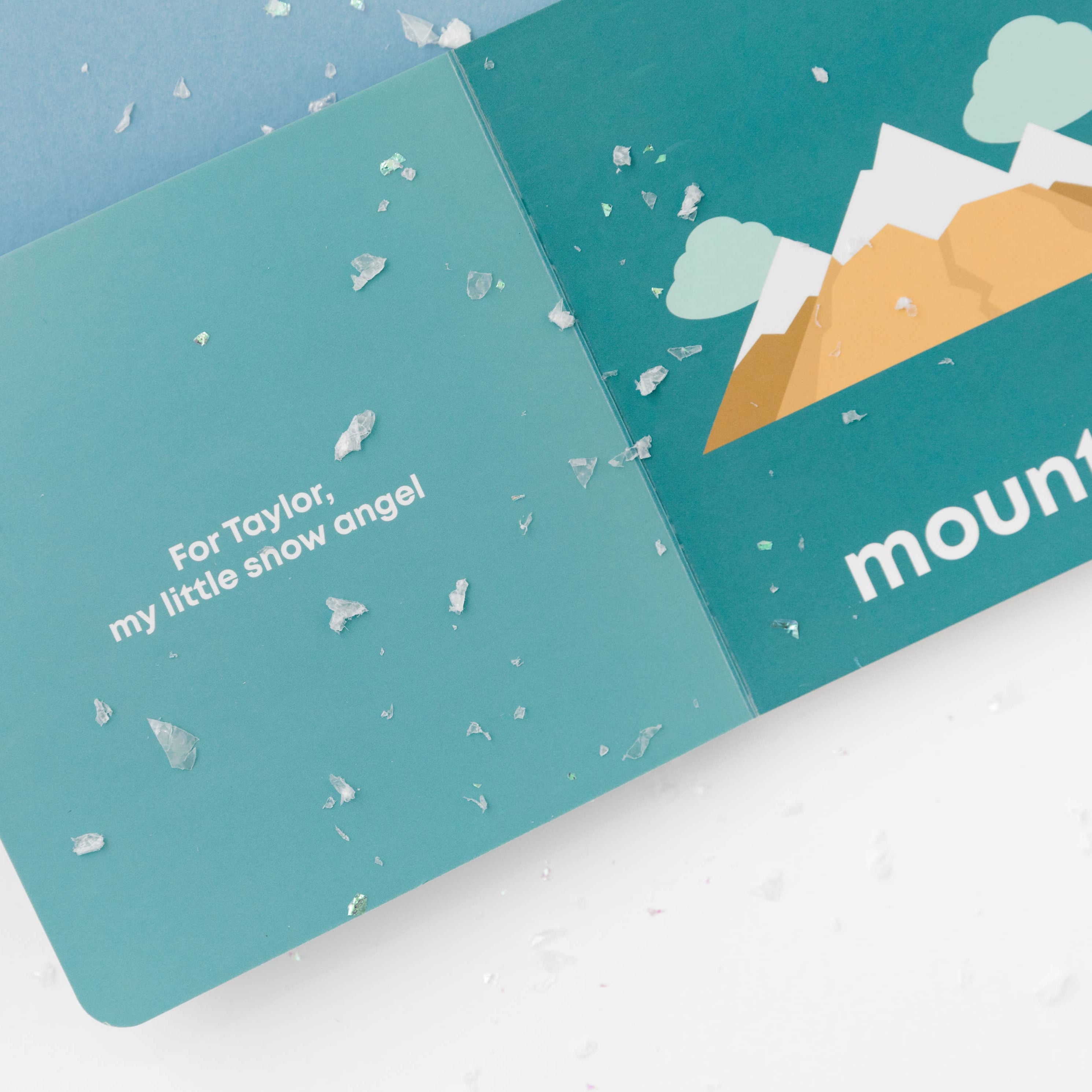 Teal gift card with mountain design and text on a white surface