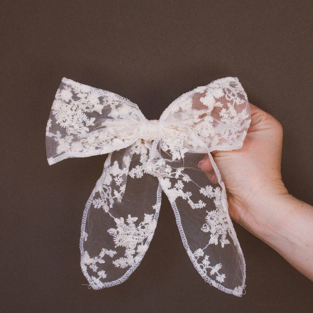 This sheer cream, lace bow, is the perfect elegant barrette for you. It has a beautiful flower lace design, a finished edge, and clips into your hair fast and easy for any updo.