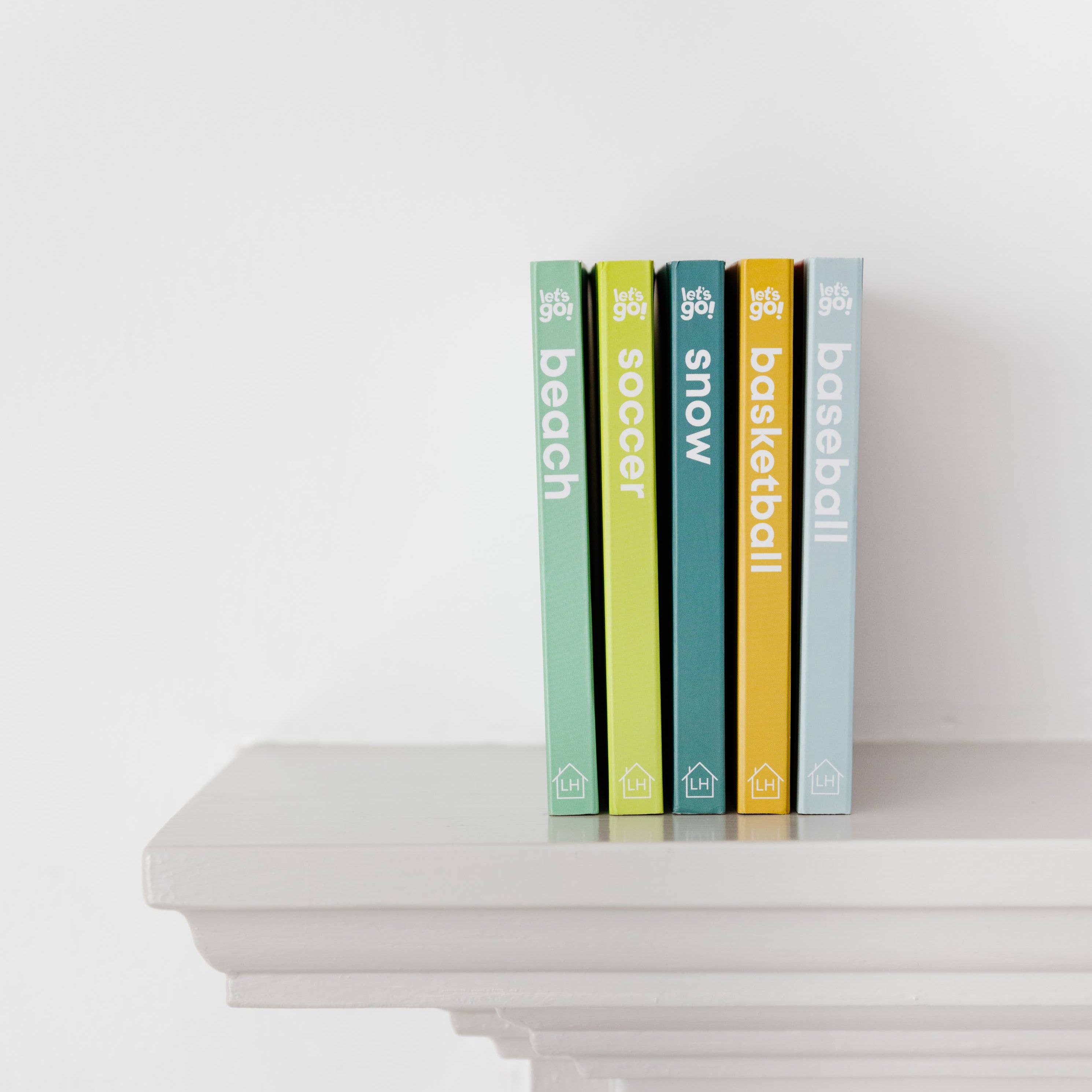 Five books with visible titles on a white surface