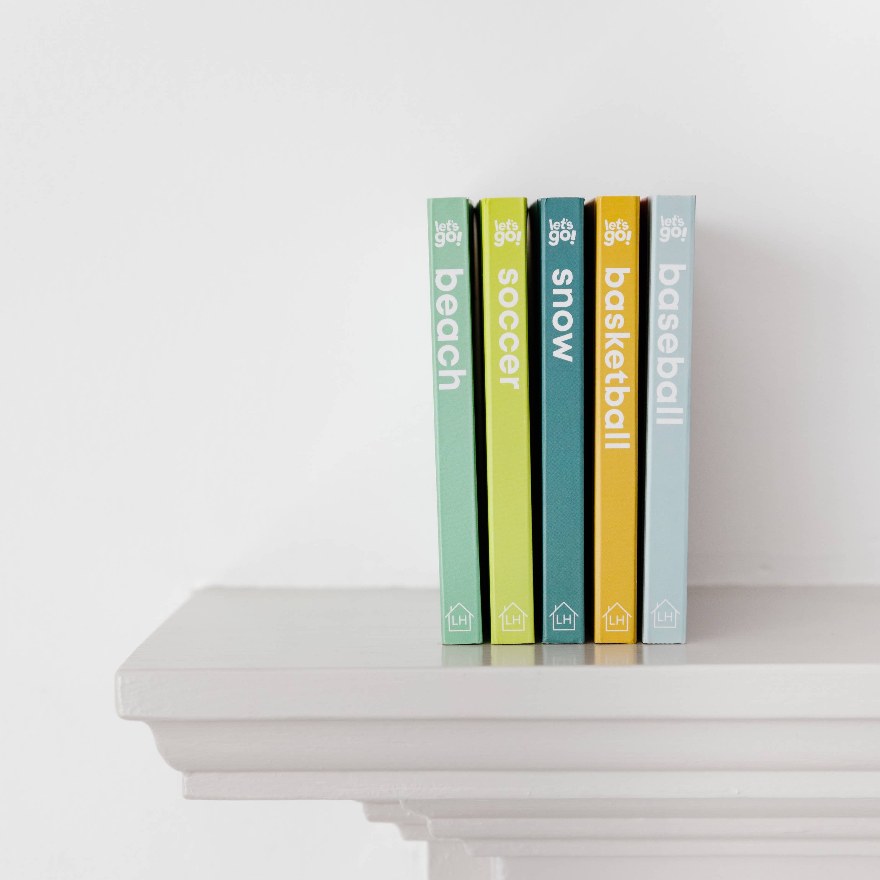 Five books with visible titles on a white surface