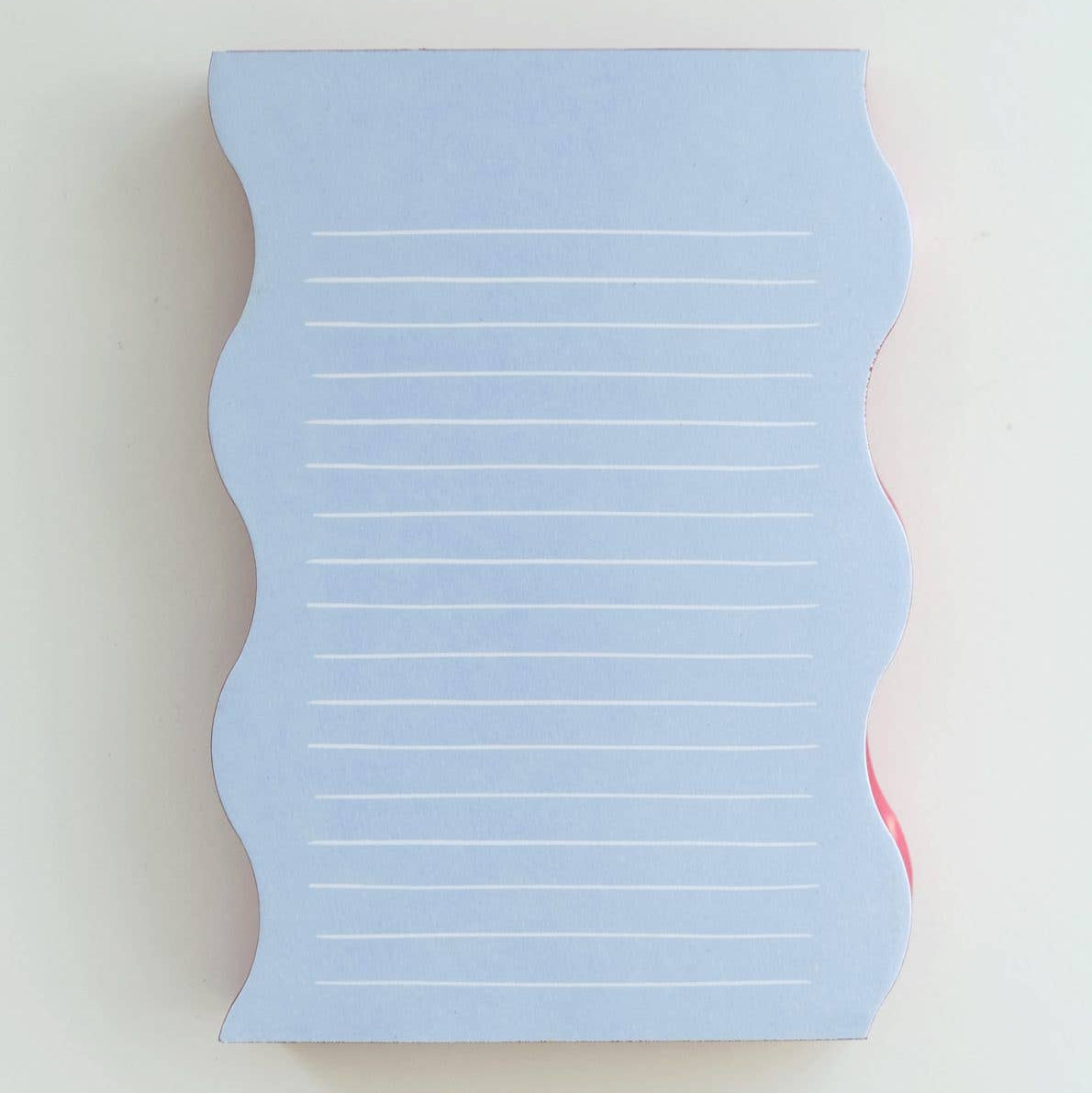 Blue notepad with lined pages on a light gray background