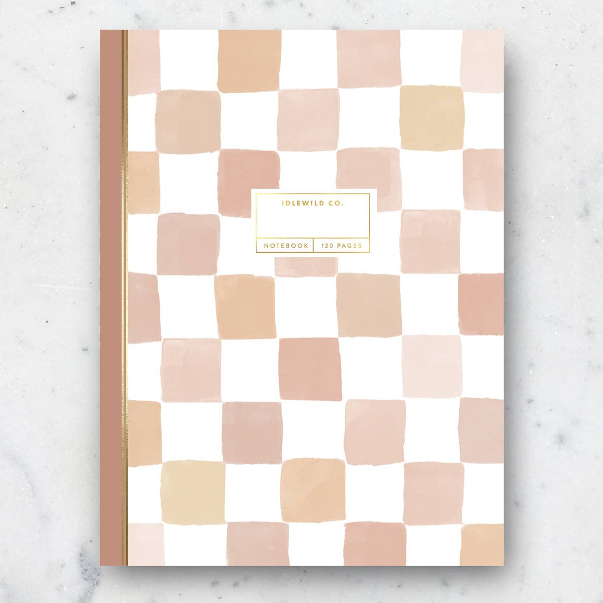 Checkered notebook with pink and beige squares on a marble surface
