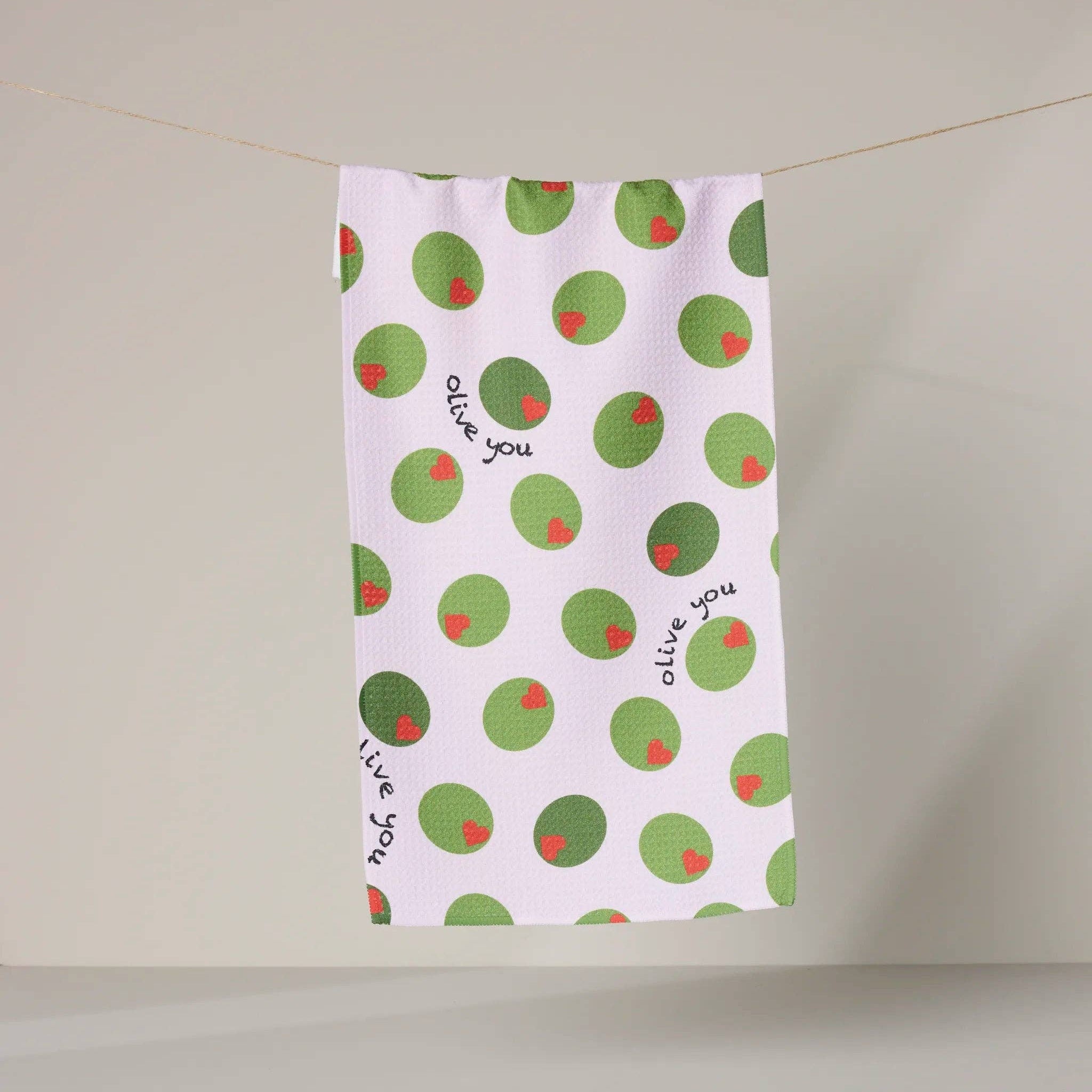 Tea towel with green olive pattern and text on a white background