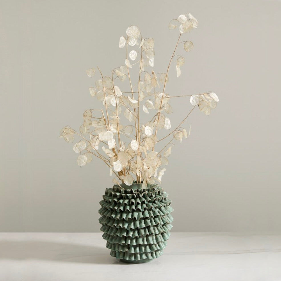 Decorative vase with branches on a plain background