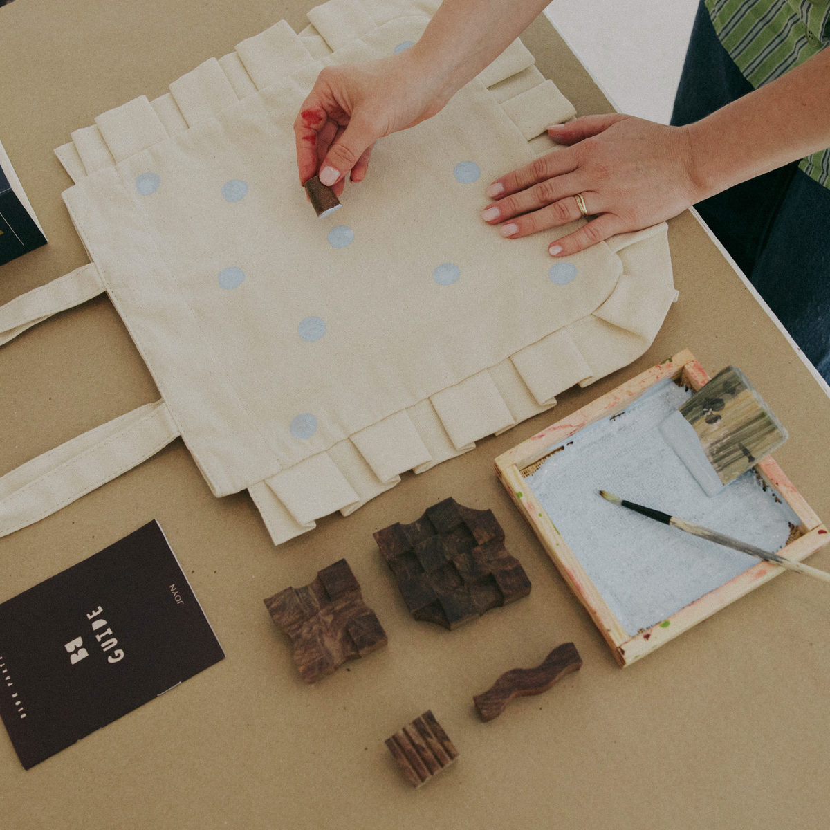 Person working with paper and printing blocks on a table
