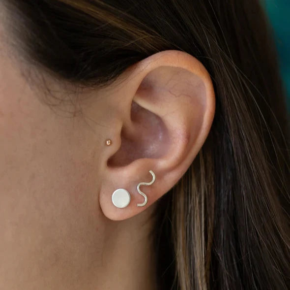 silver wiggle dot earrings on models ear