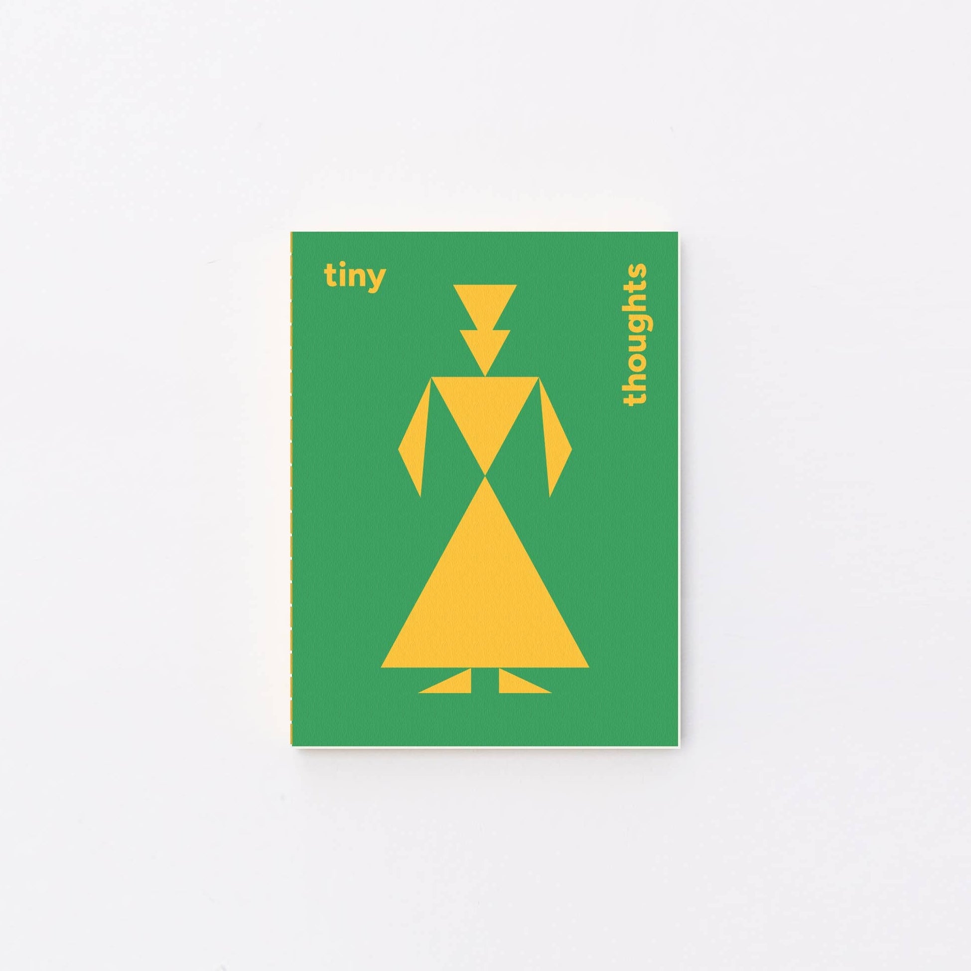 A rectangular green tiny notebook with a yellow geometric figure and the words 'tiny thoughts' in yellow, centered on a plain white background.