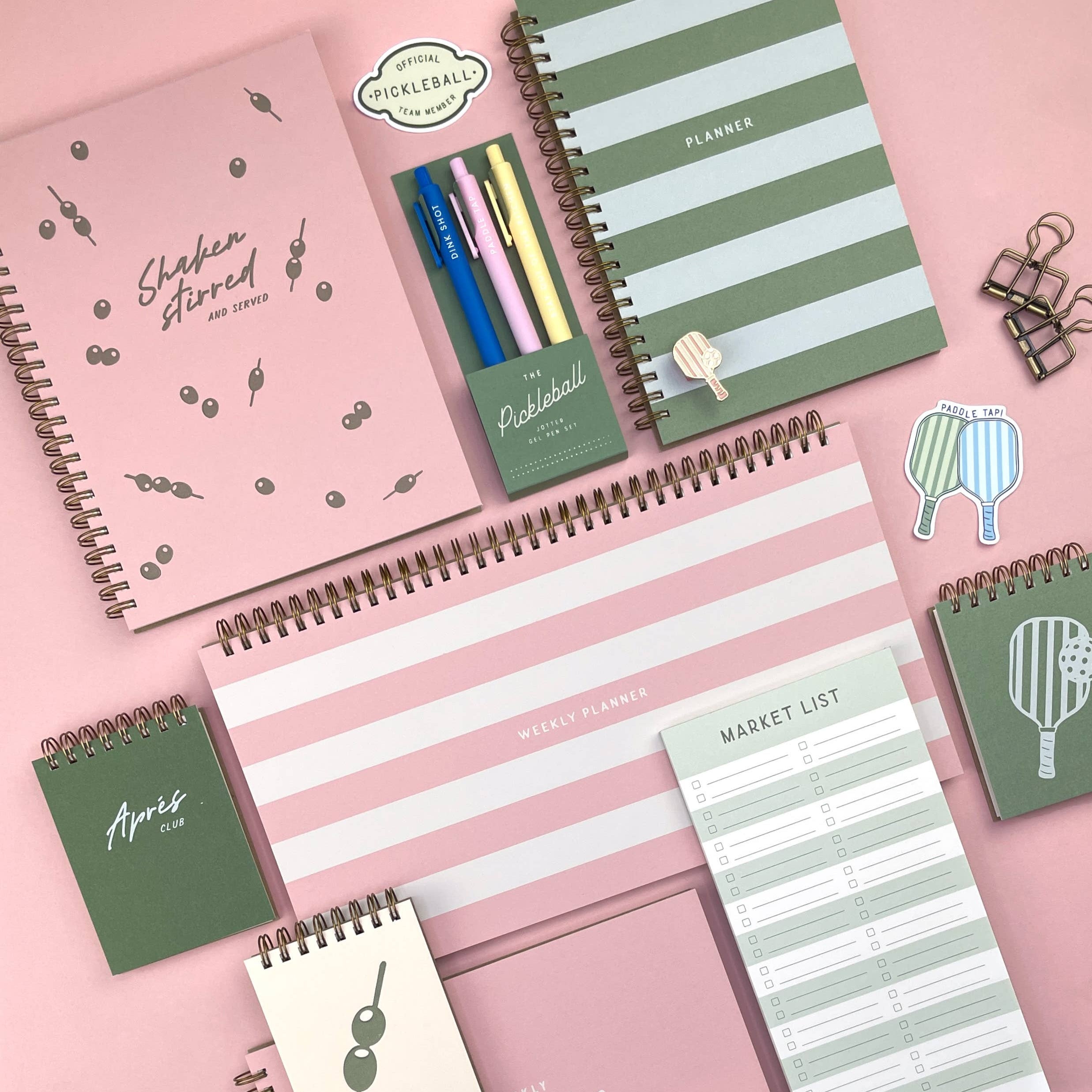 Collection of planners and stationery items on a pink background