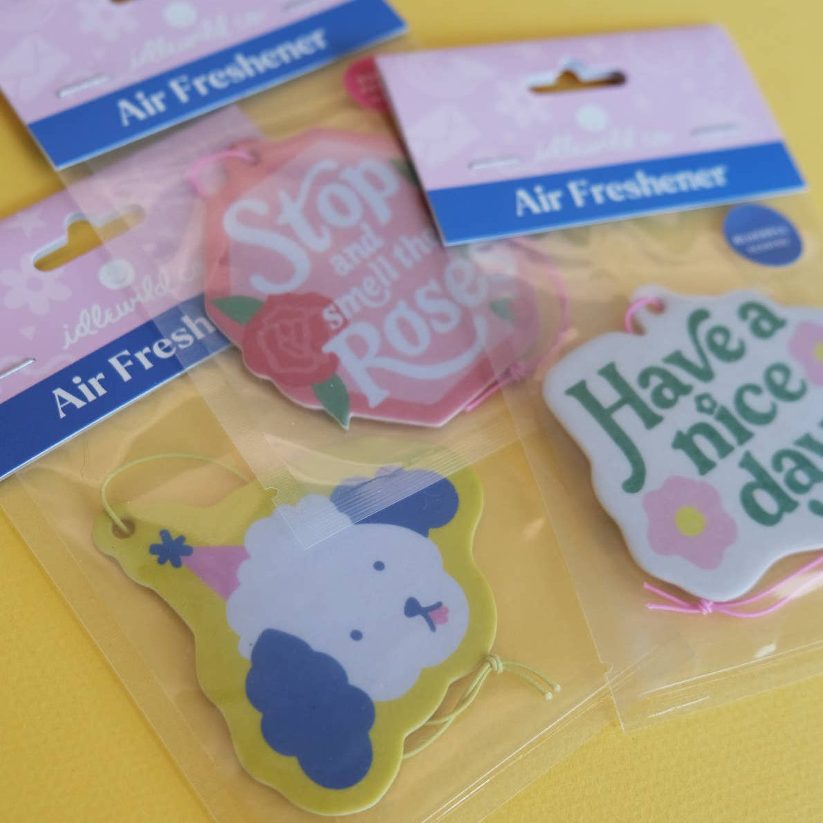 Decorative air freshener with 'Have a nice day' text and flowers on a white background