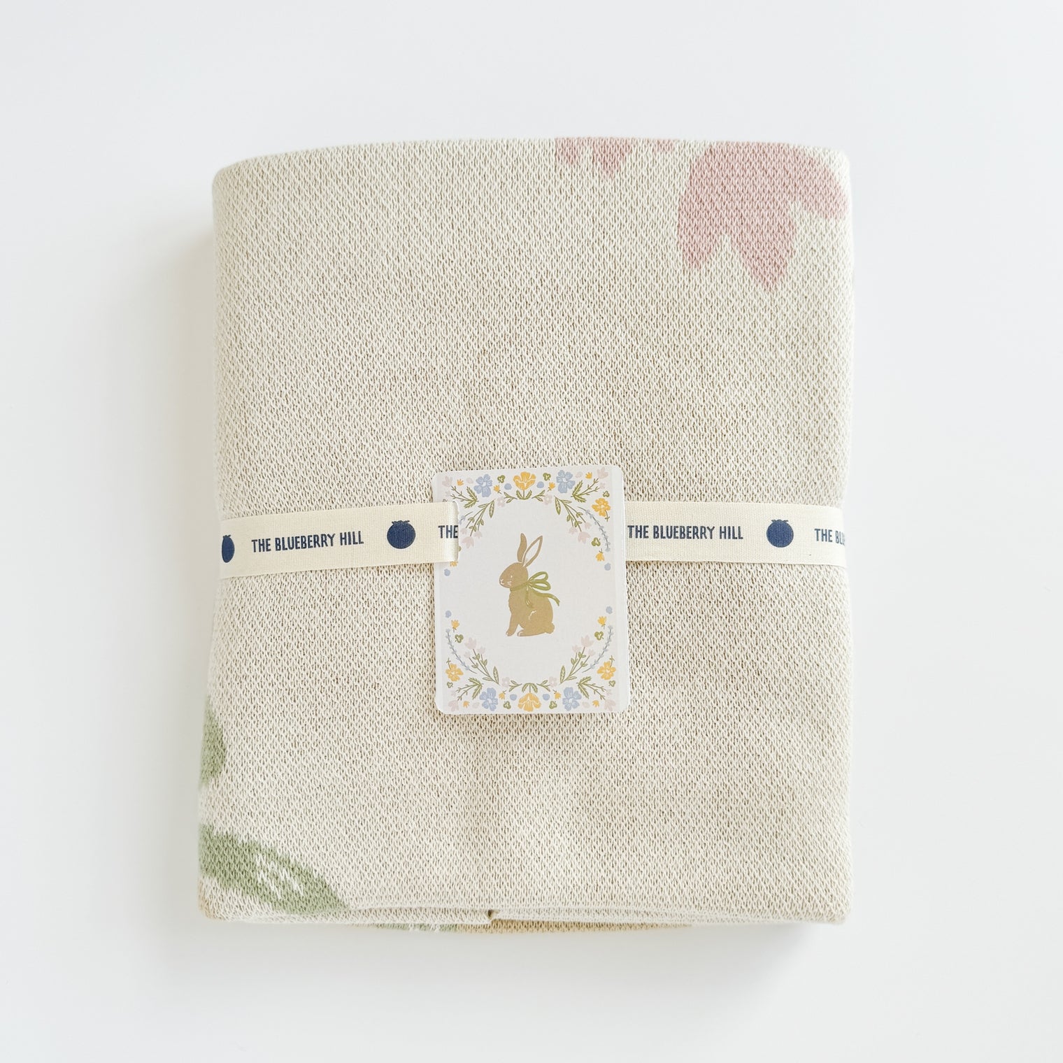 This organic cotton floral blanket centers around a sweet bunny with a bow. Snuggle in it. Decorate with it. Get the matching bunny lovey, baby rattles, or greeting card to complete the gift set.