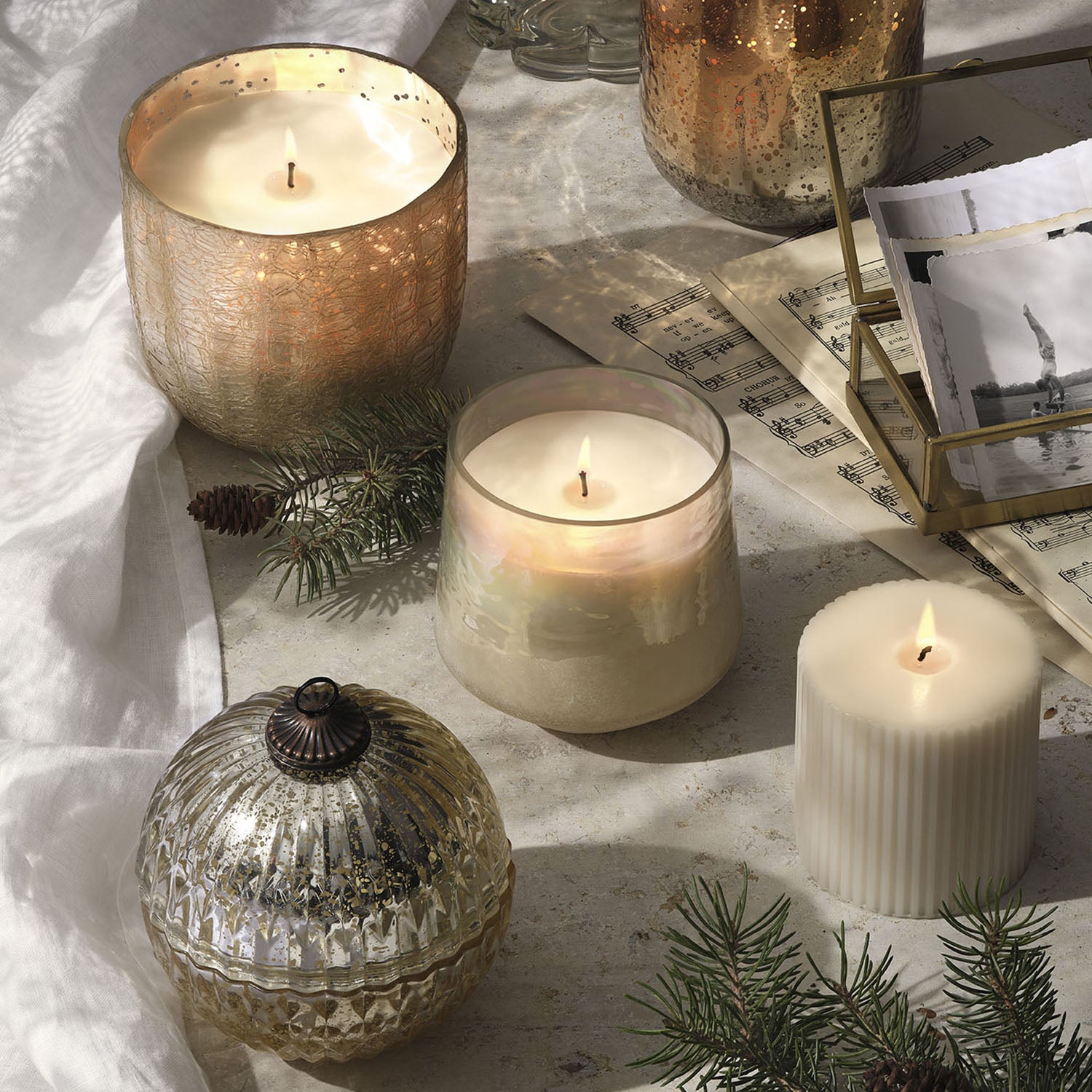 Decorative candles and ornaments on a textured surface with a soft focus