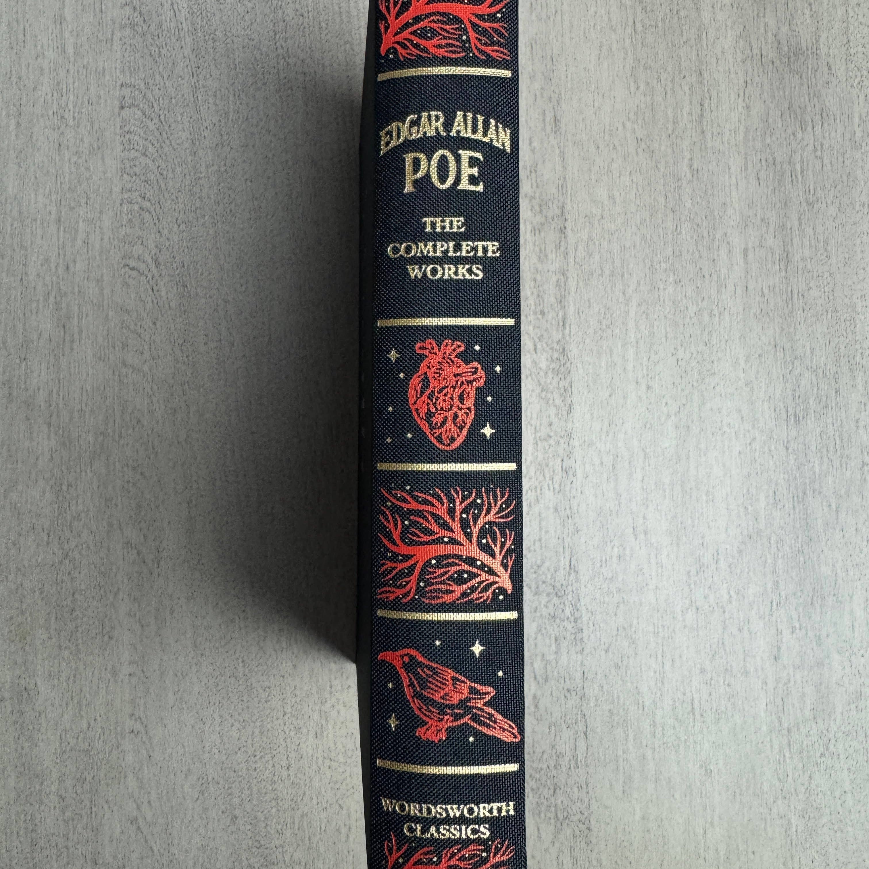 Book titled 'The Complete Works of Edgar Allan Poe' with decorative cover on a gray background