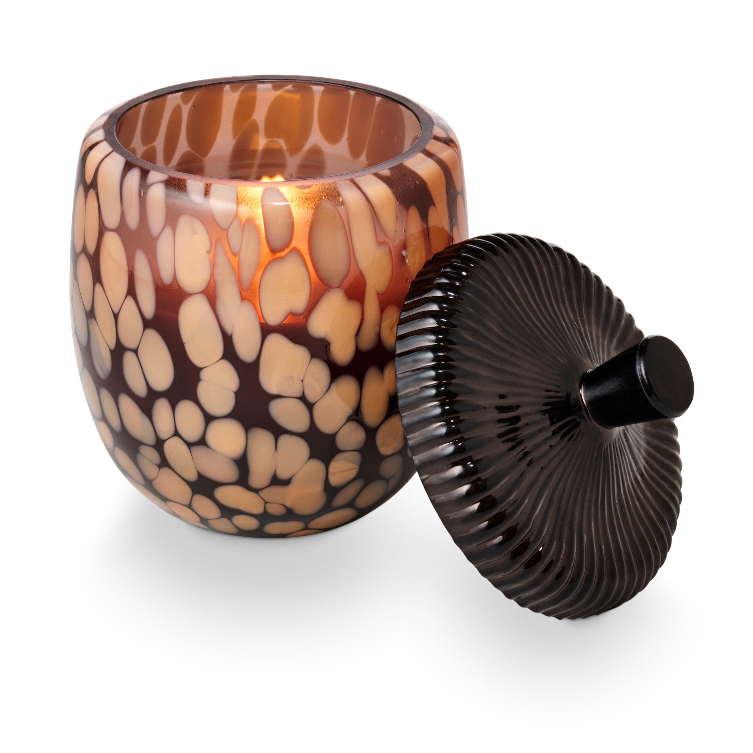 Decorative candle holder with a patterned glass container and black lid on a white background