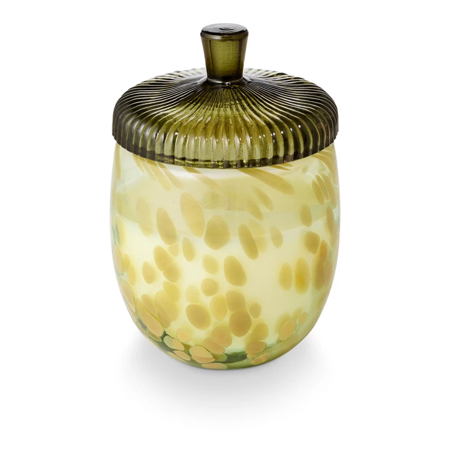 Decorative glass jar with a textured green lid on a white background