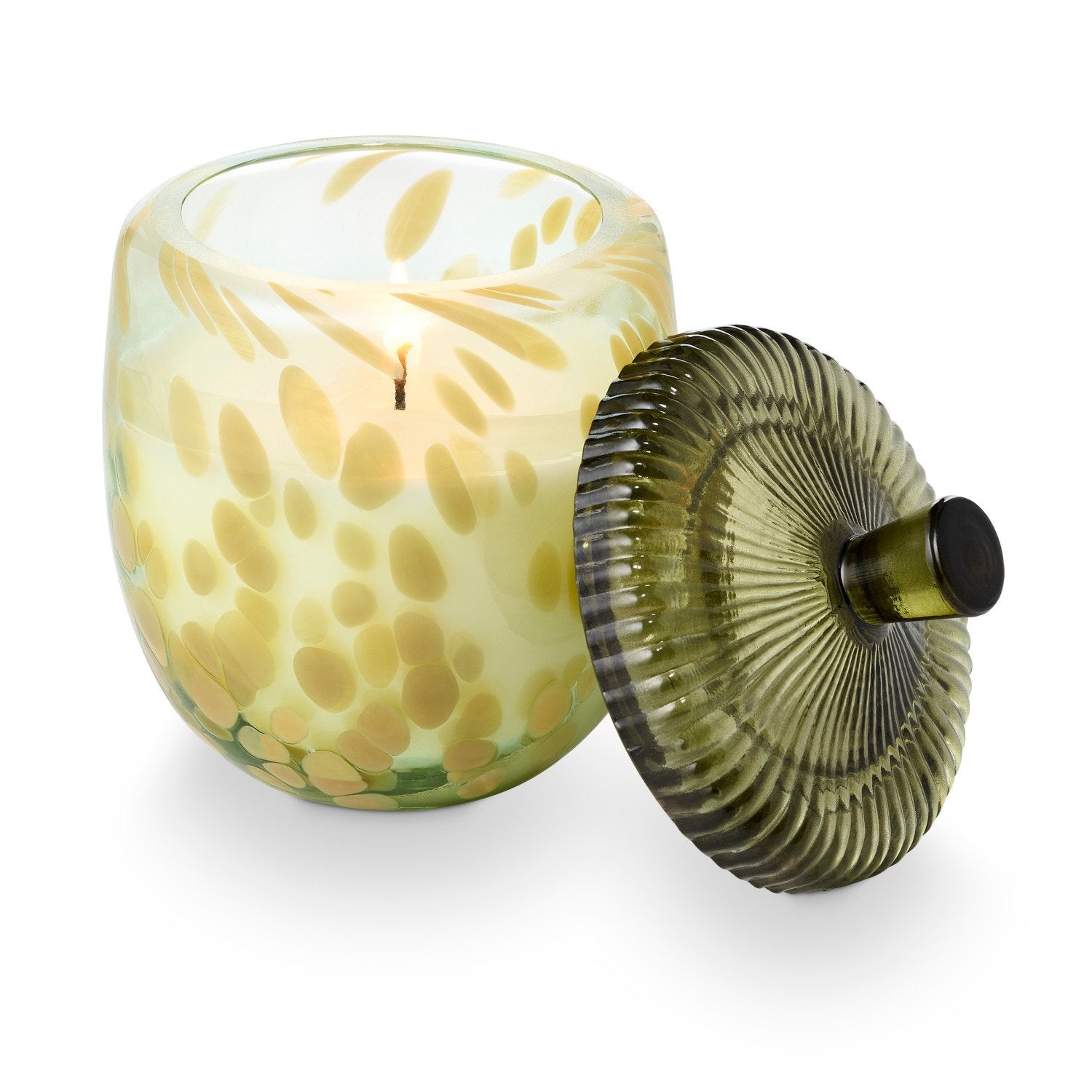Decorative glass candle with a textured lid on a white background