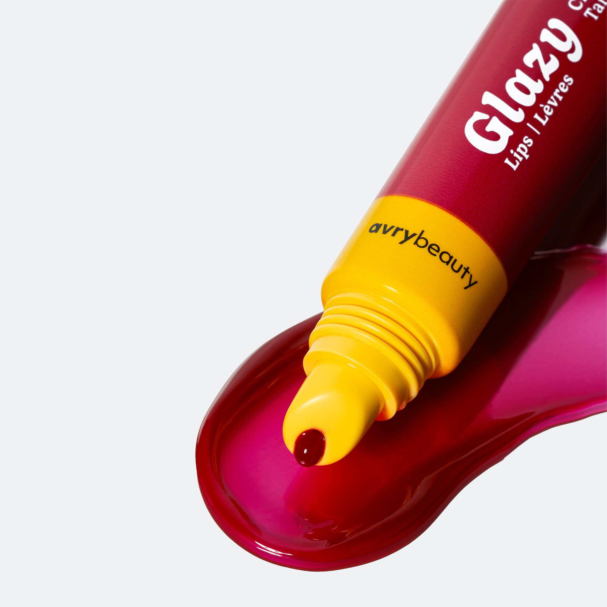 Red lip gloss tube with yellow cap on a white background