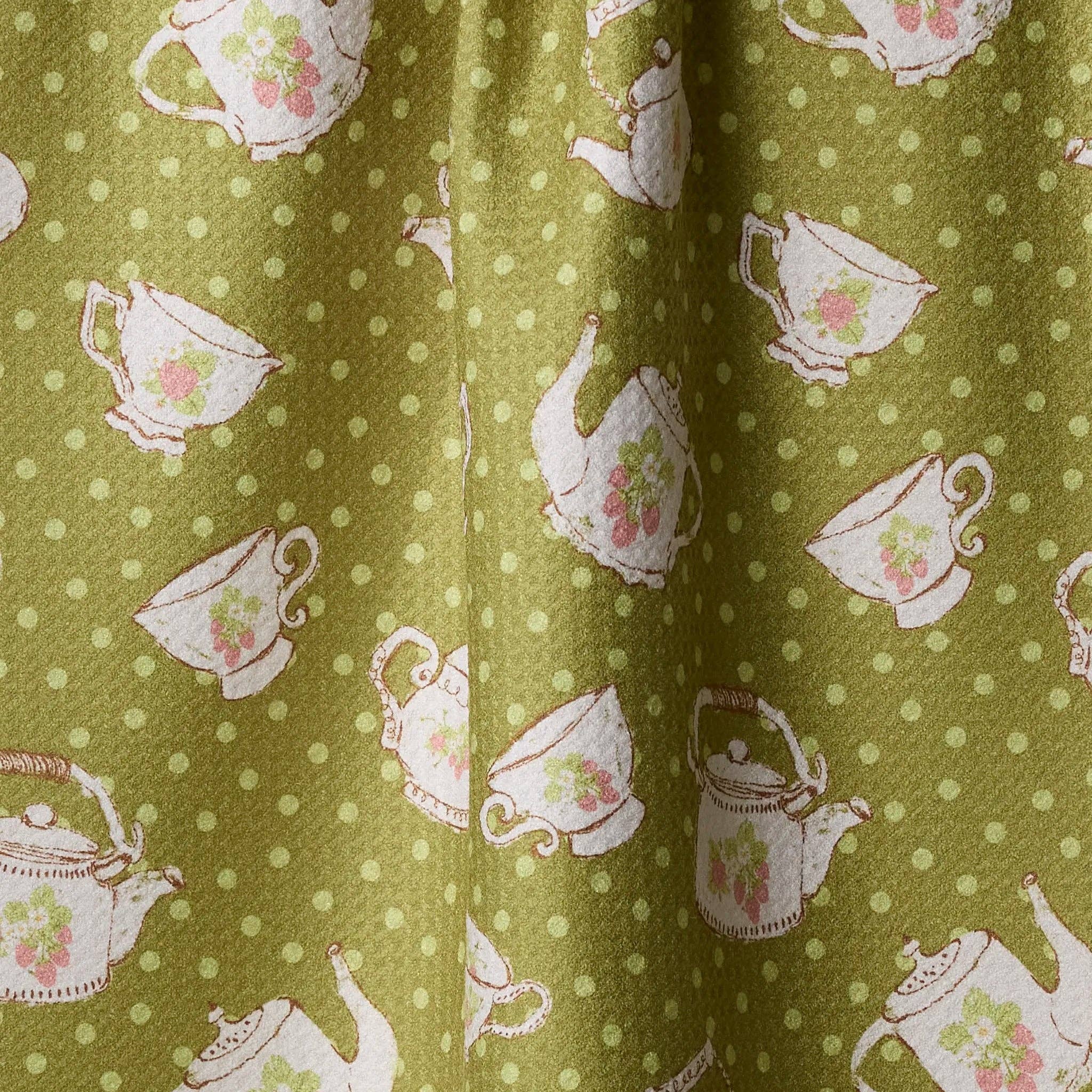 tea towel with teapot and cup pattern on a green background