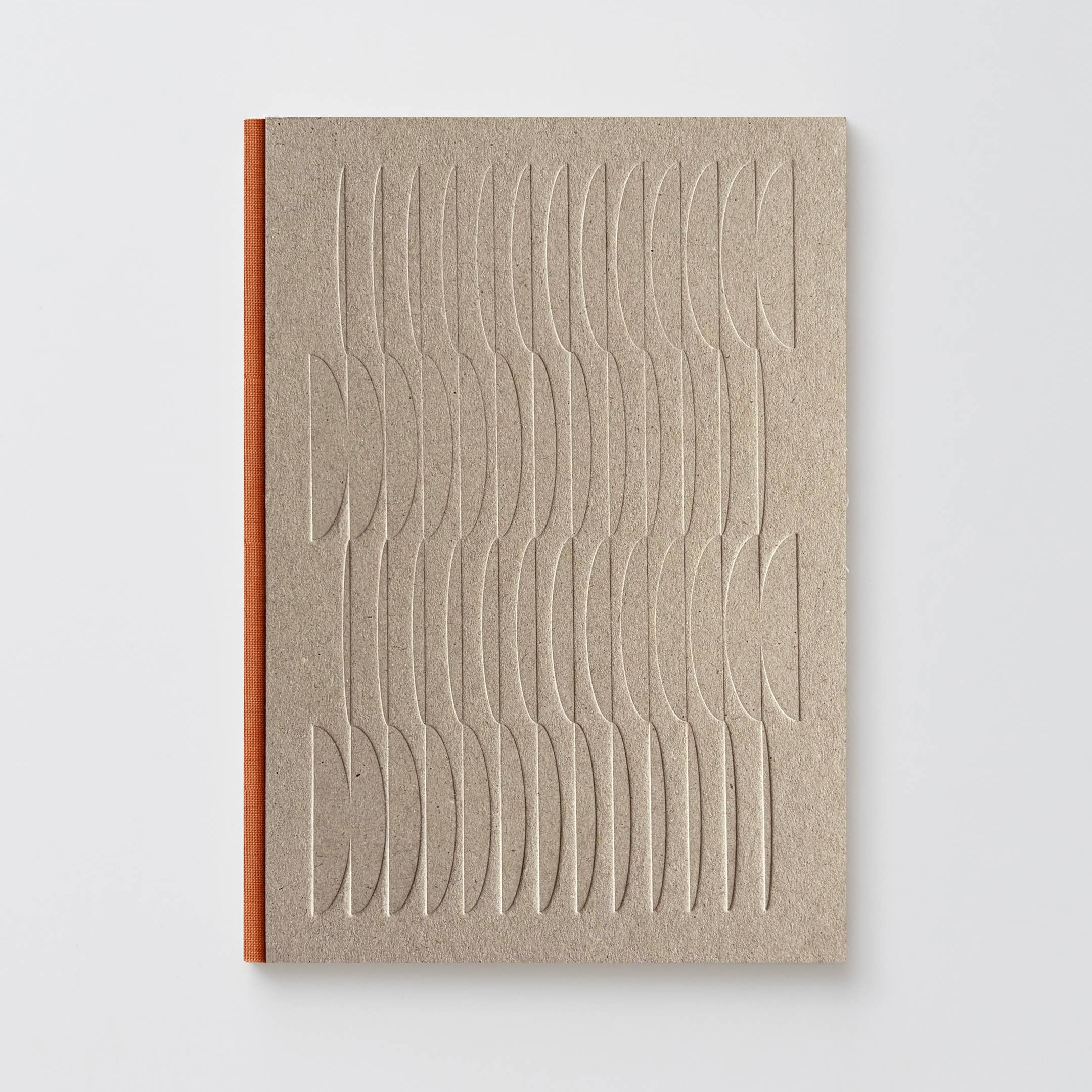 A minimalist notebook with a textured beige cover featuring an embossed wavy geometric pattern, bound with a contrasting orange-brown spine, set against a clean light gray background.