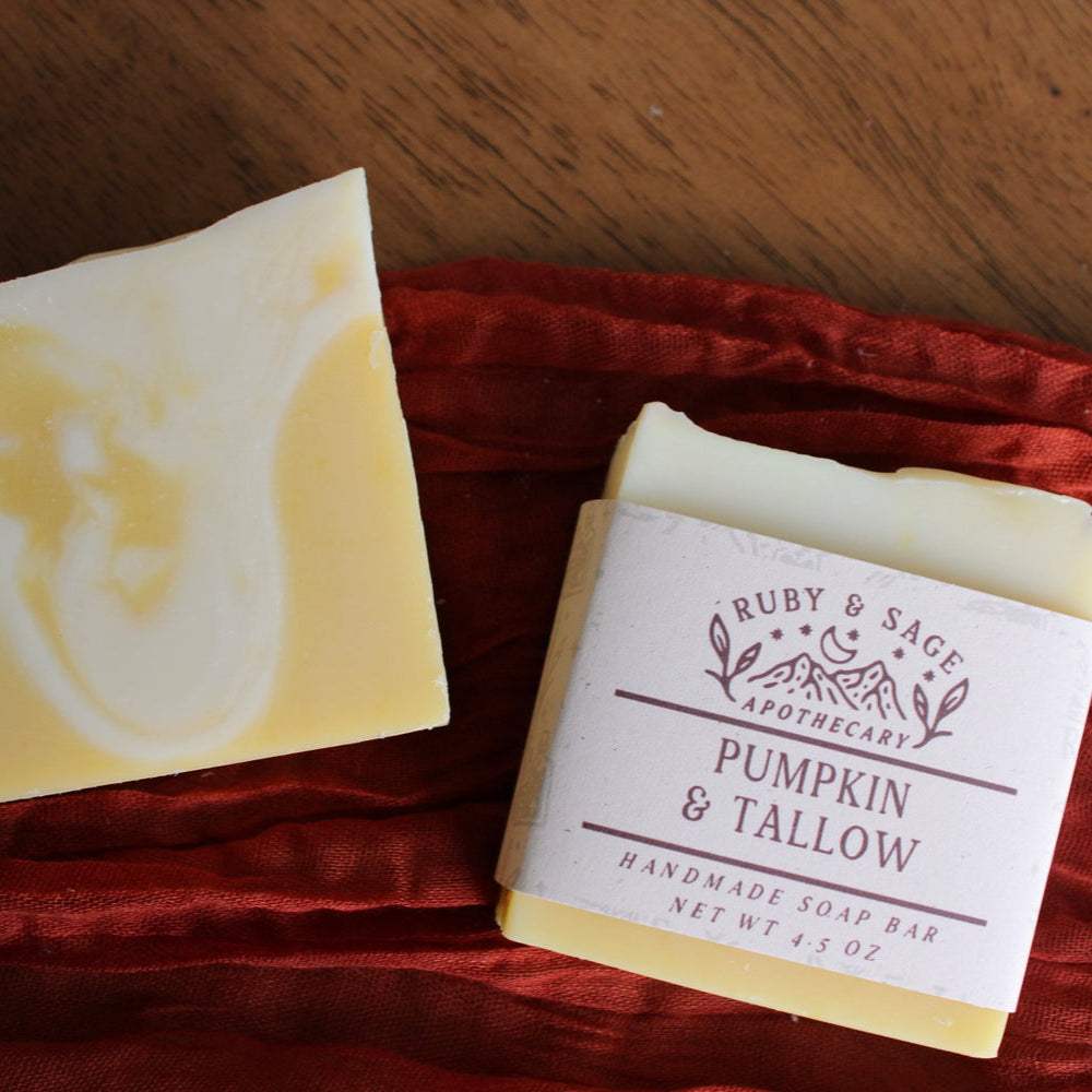 Bars of warm yellow soap with white swirls, sitting against a rust color table runner.
