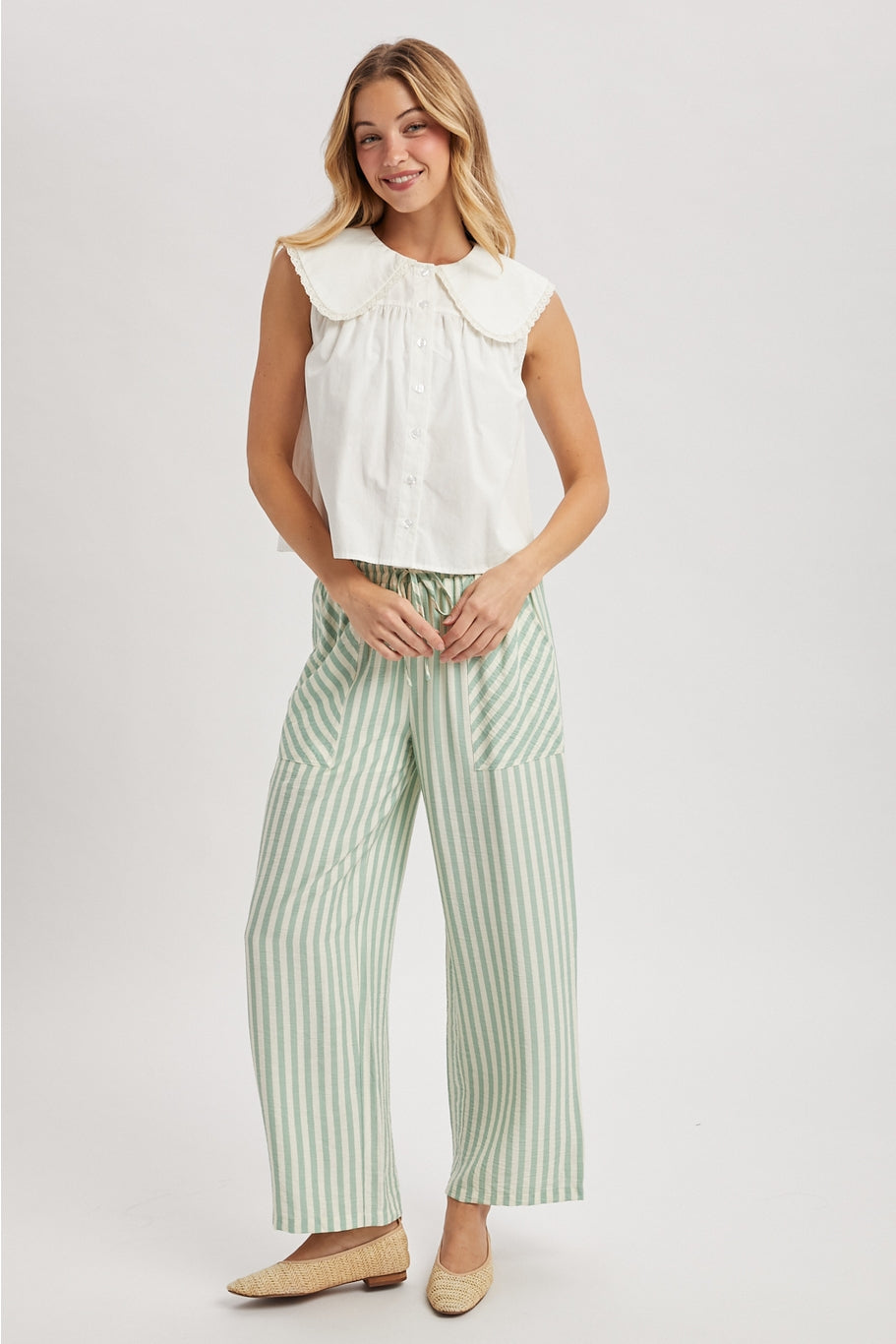 White sleeveless blouse with buttons and a large lace edged pan collar.