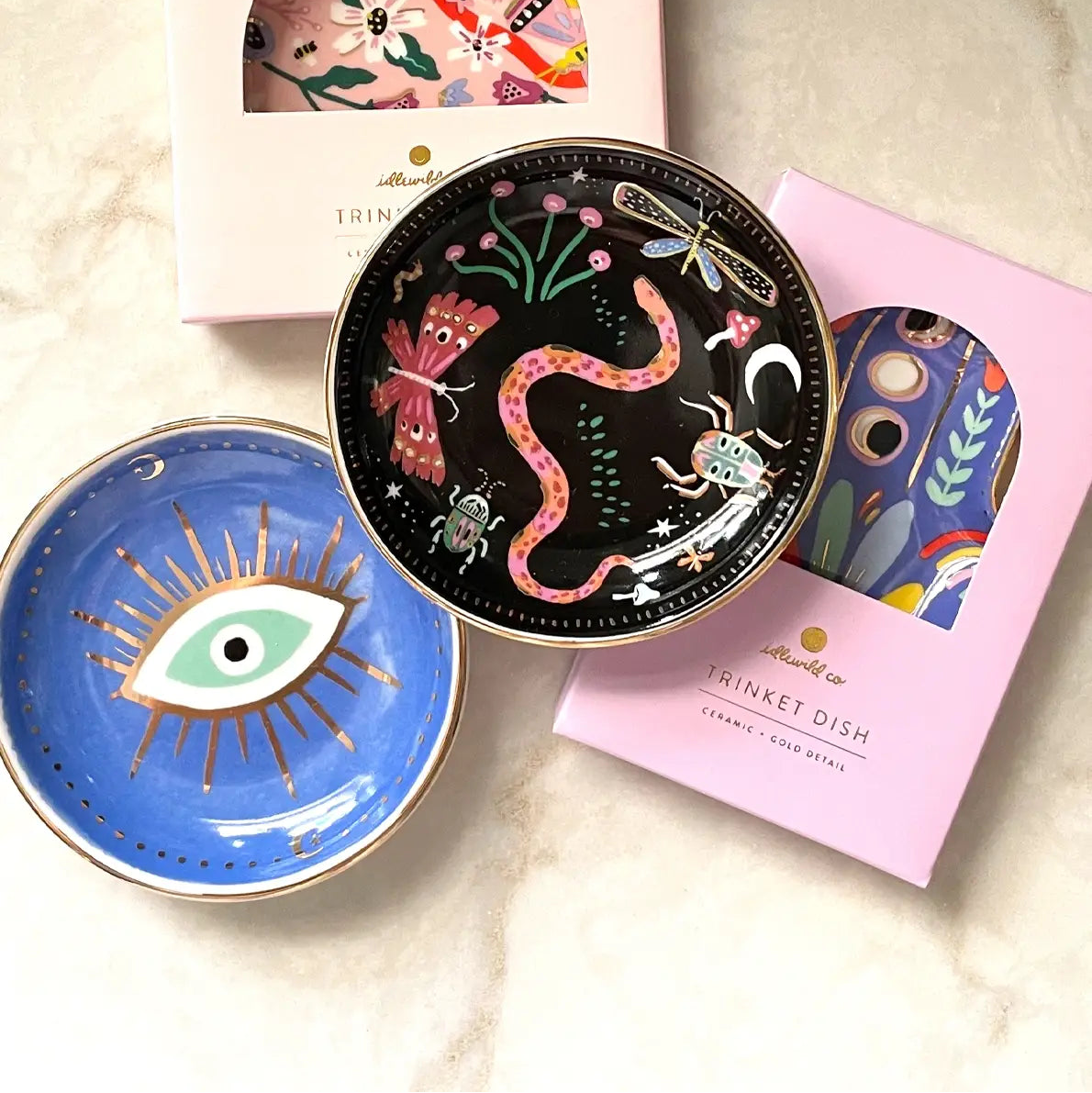 Set of decorative trinket dishes with artistic designs on a marble surface.