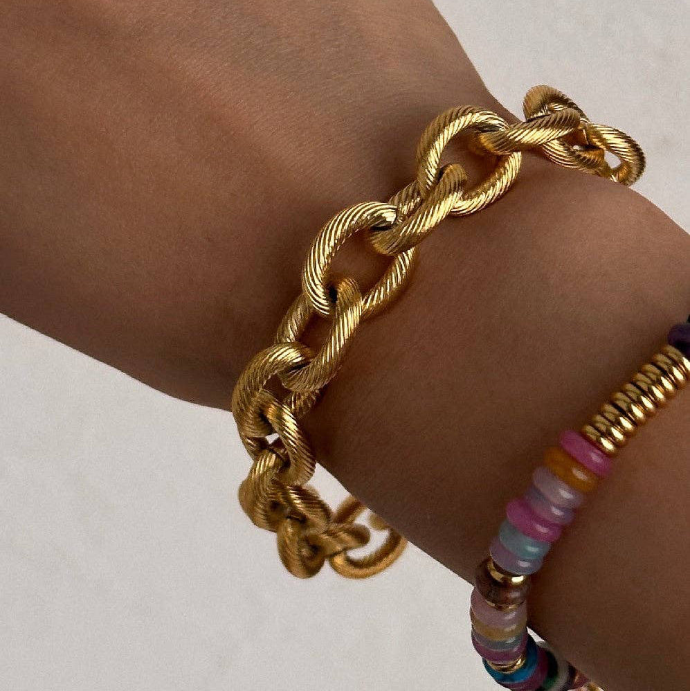 Elevate your everyday style with this striking 18K gold plated chunky link chain bracelet. Crafted from hypoallergenic stainless steel, it features a textured toggle clasp for secure, effortless wear. Waterproof and tarnish-resistant, this versatile piece withstands daily activities and moisture exposure. To maintain its lustrous finish, minimize contact with lotions, perfumes, and cleaning products. A timeless accessory that combines durability with sophisticated design.