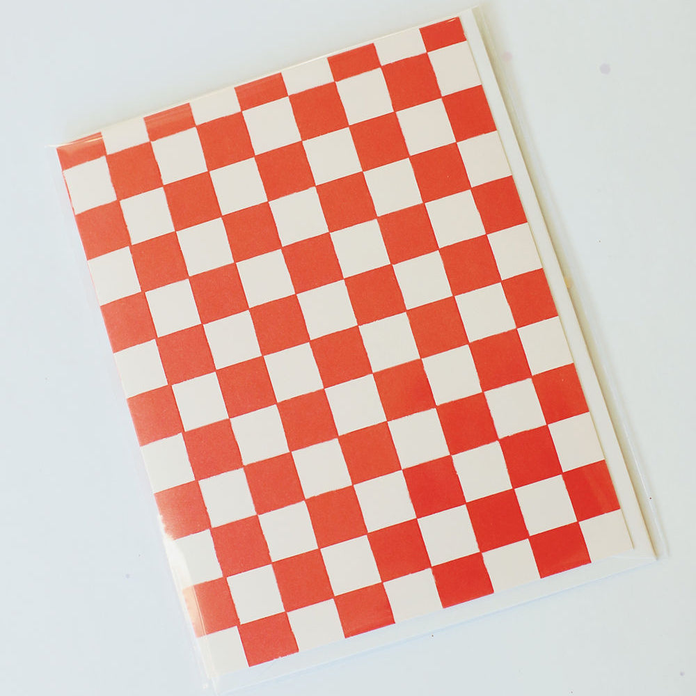 Red and white checkered card pictured abasing a white back ground.