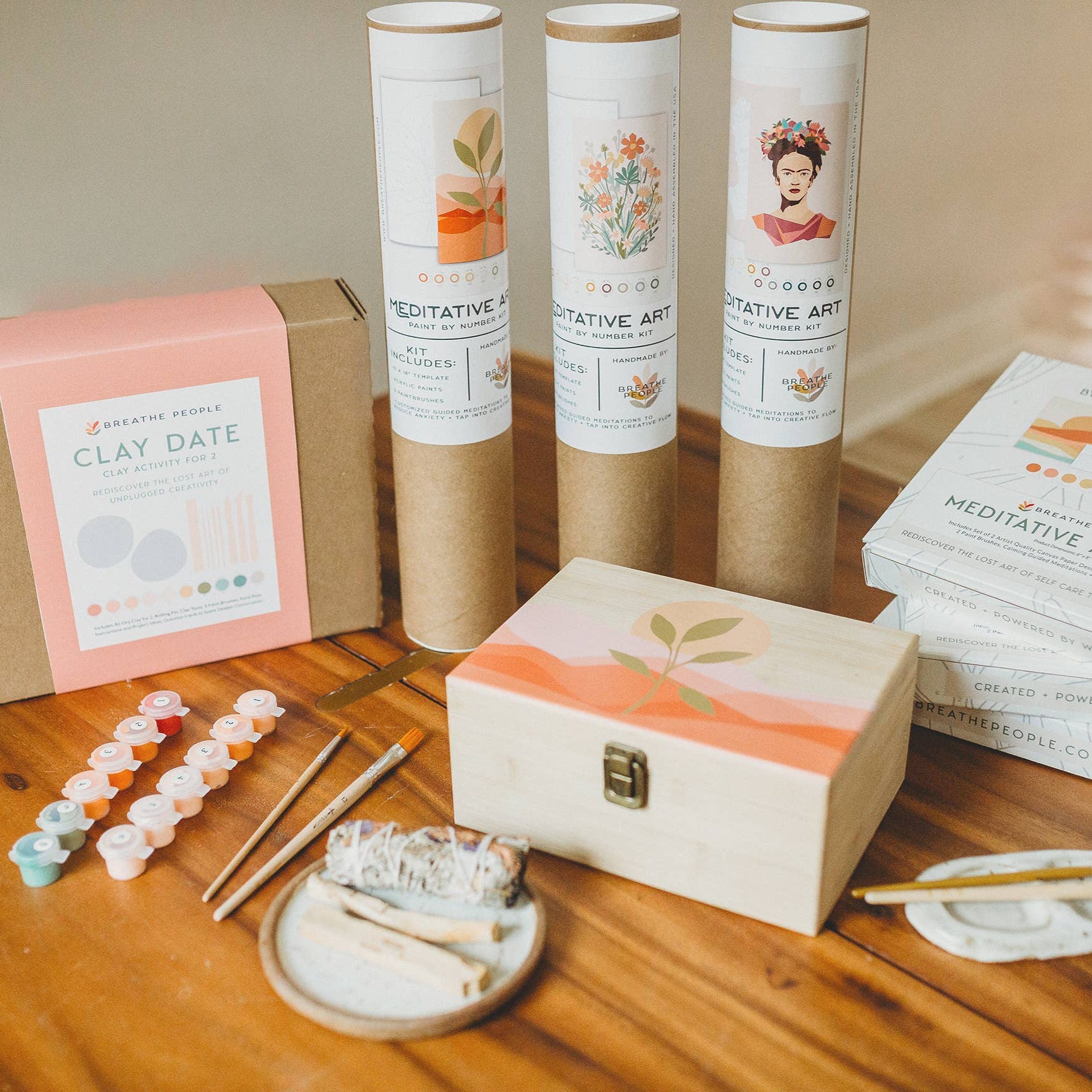 Meditative Art Kits packaging on a wooden surface with art supplies.