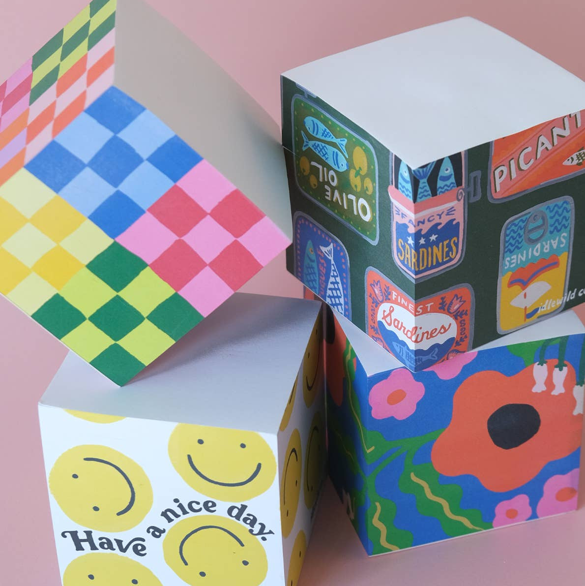 Colorful cardboard boxes with various designs on a pink background