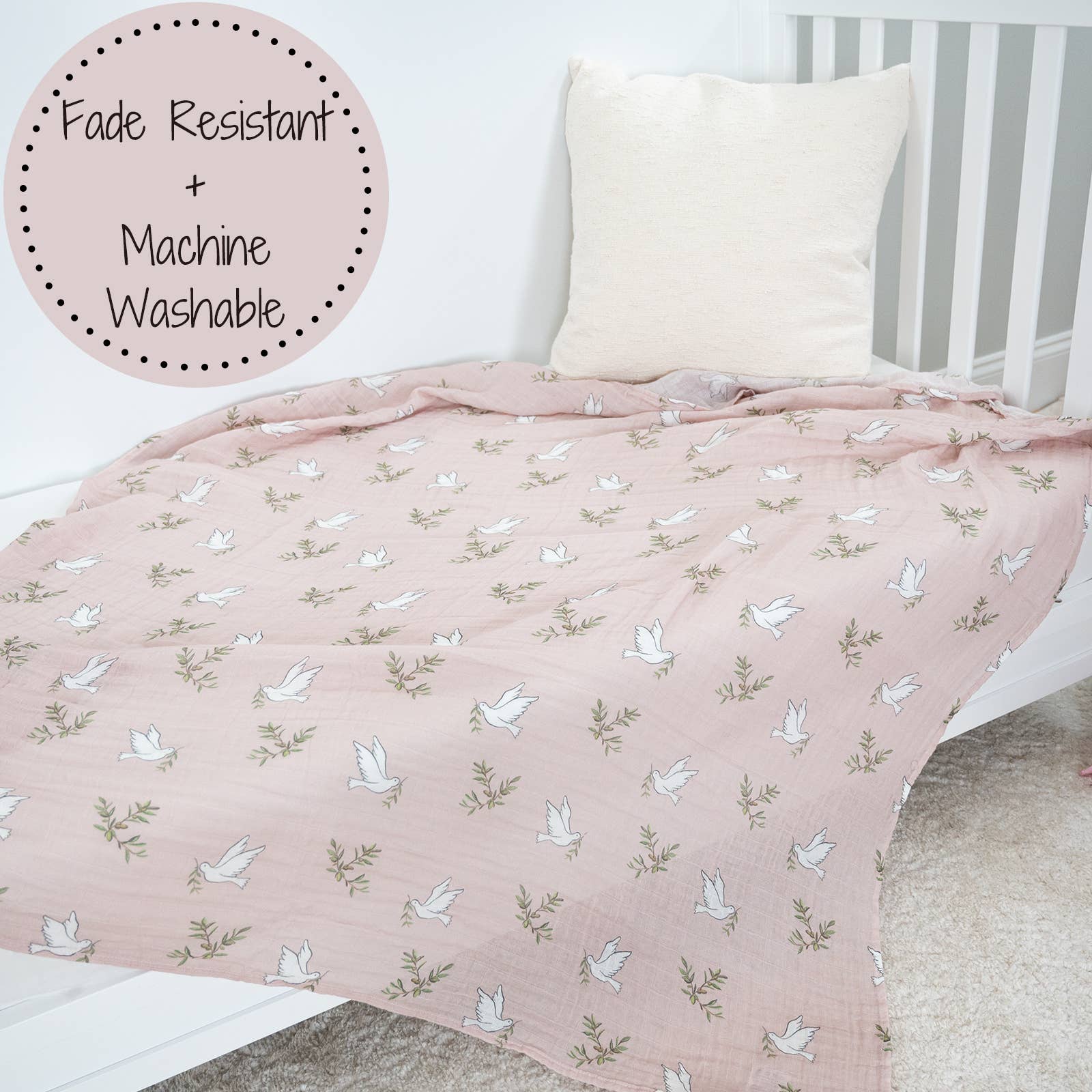 Pink quilt with bird pattern on a bed, featuring 'Fade Resistant' and 'Machine Washable' text.