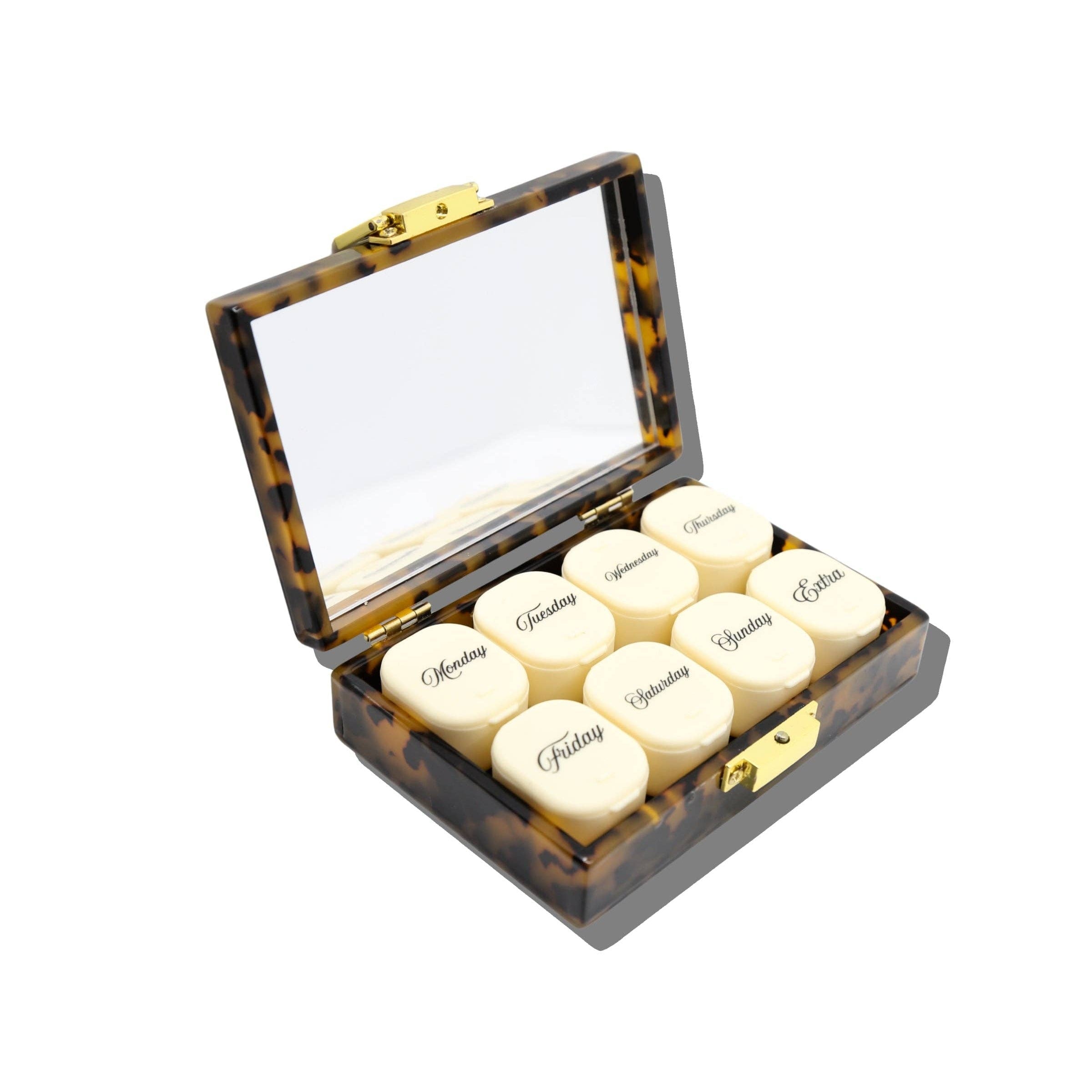 A tortoiseshell medicine box with an open mirror lid and six cream-colored round pill bottles labeled with drug names, shown on a white background.