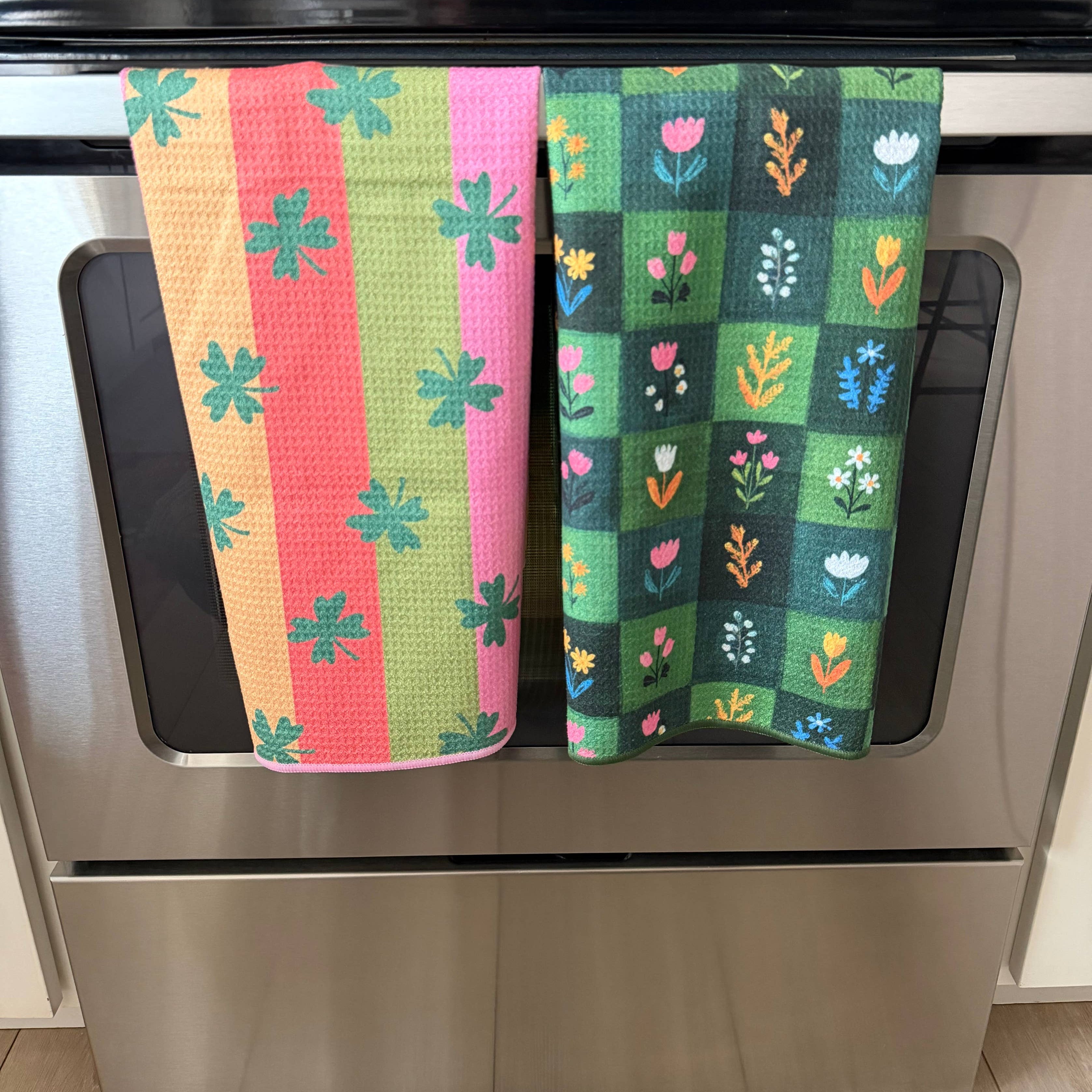 Colorful patterned towels hanging on a stove handle