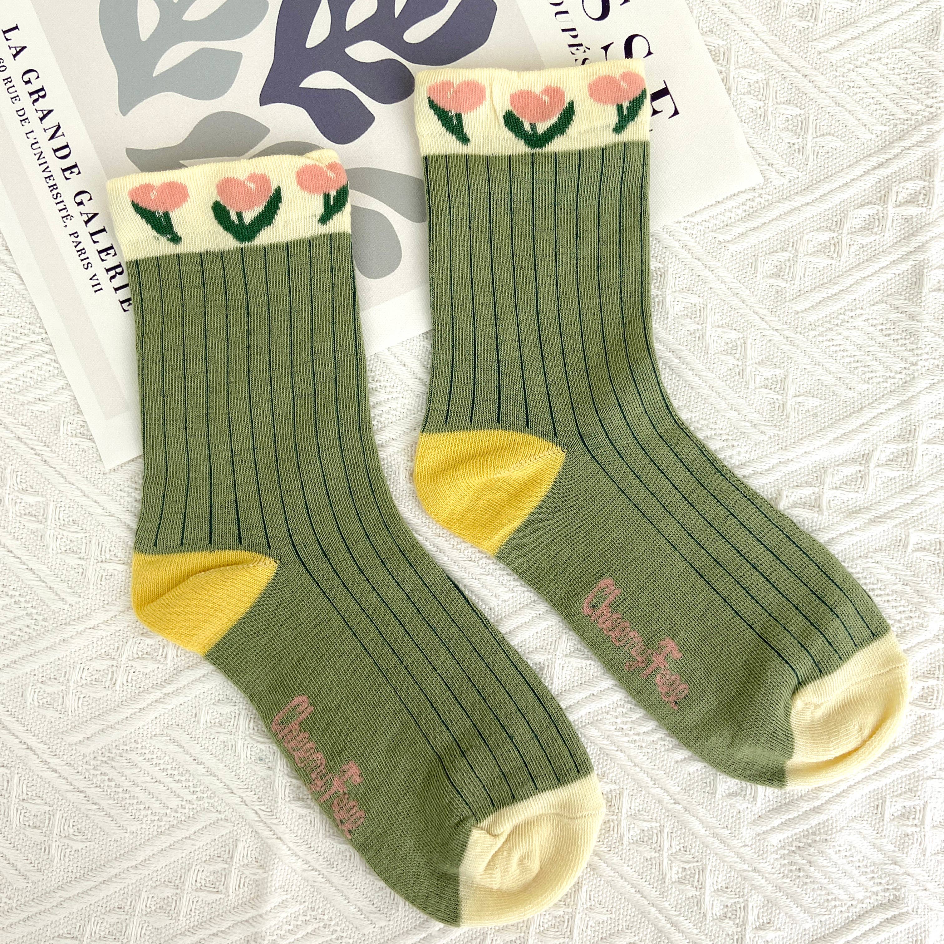 Step into comfort with these charming mid-calf socks featuring a delightful tulip pattern on an olive green base, accented with yellow, pink and cream. The vintage-inspired design brings a touch of timeless elegance to your everyday wardrobe, perfect for adding personality to any outfit. Whether you're dressing up or keeping it casual, these floral socks offer the cozy support you deserve while celebrating your unique style.