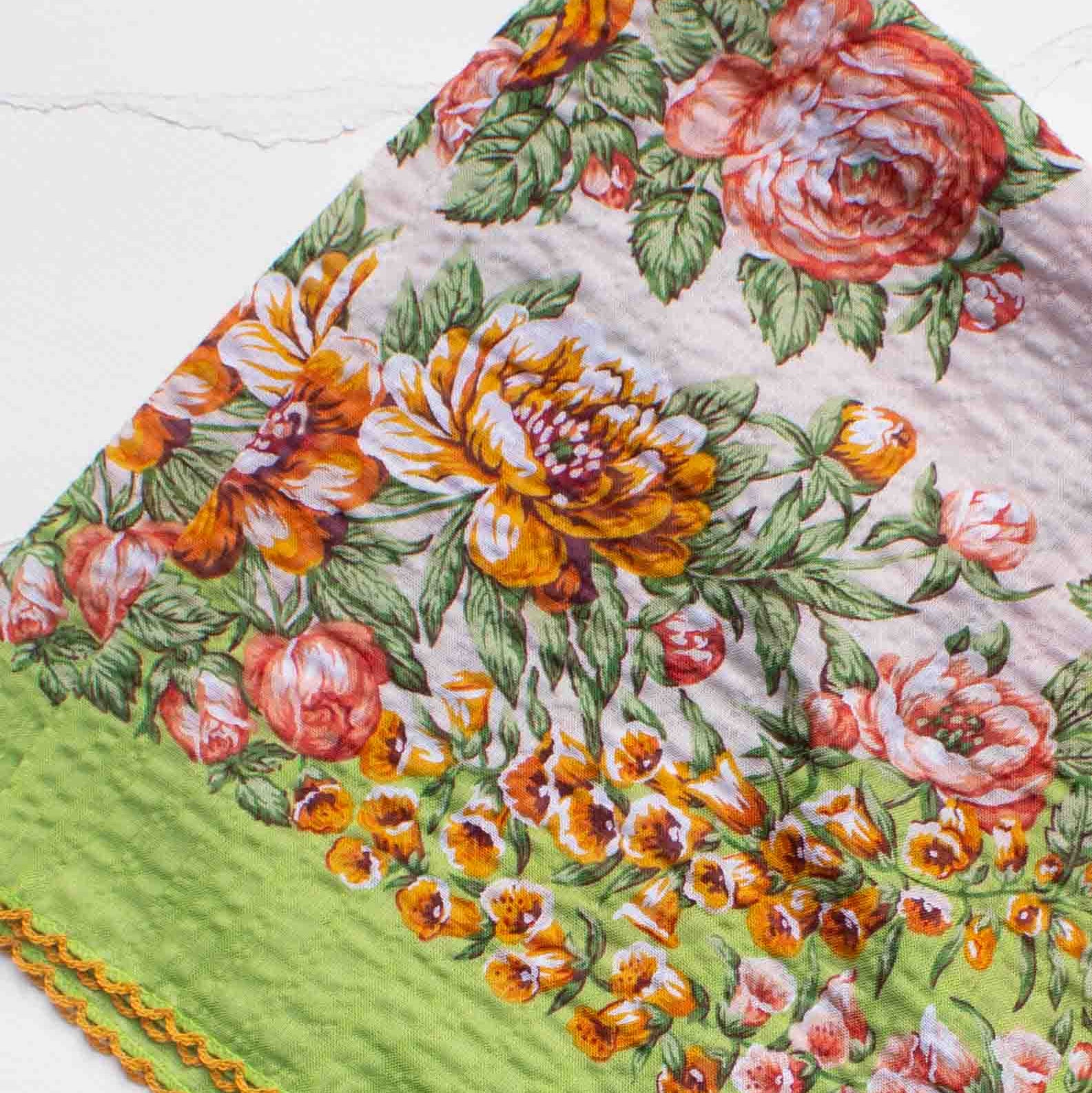 Floral patterned fabric with green border on a white background