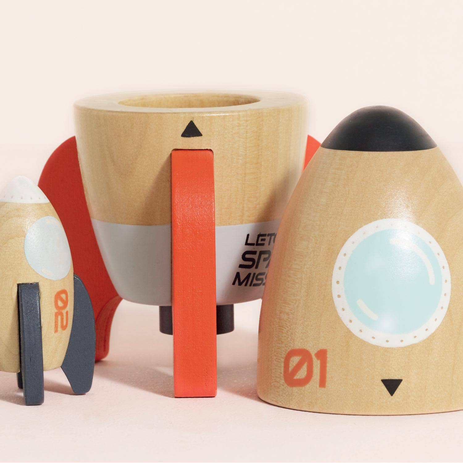 Wooden toy spaceships with colorful design on a light background
