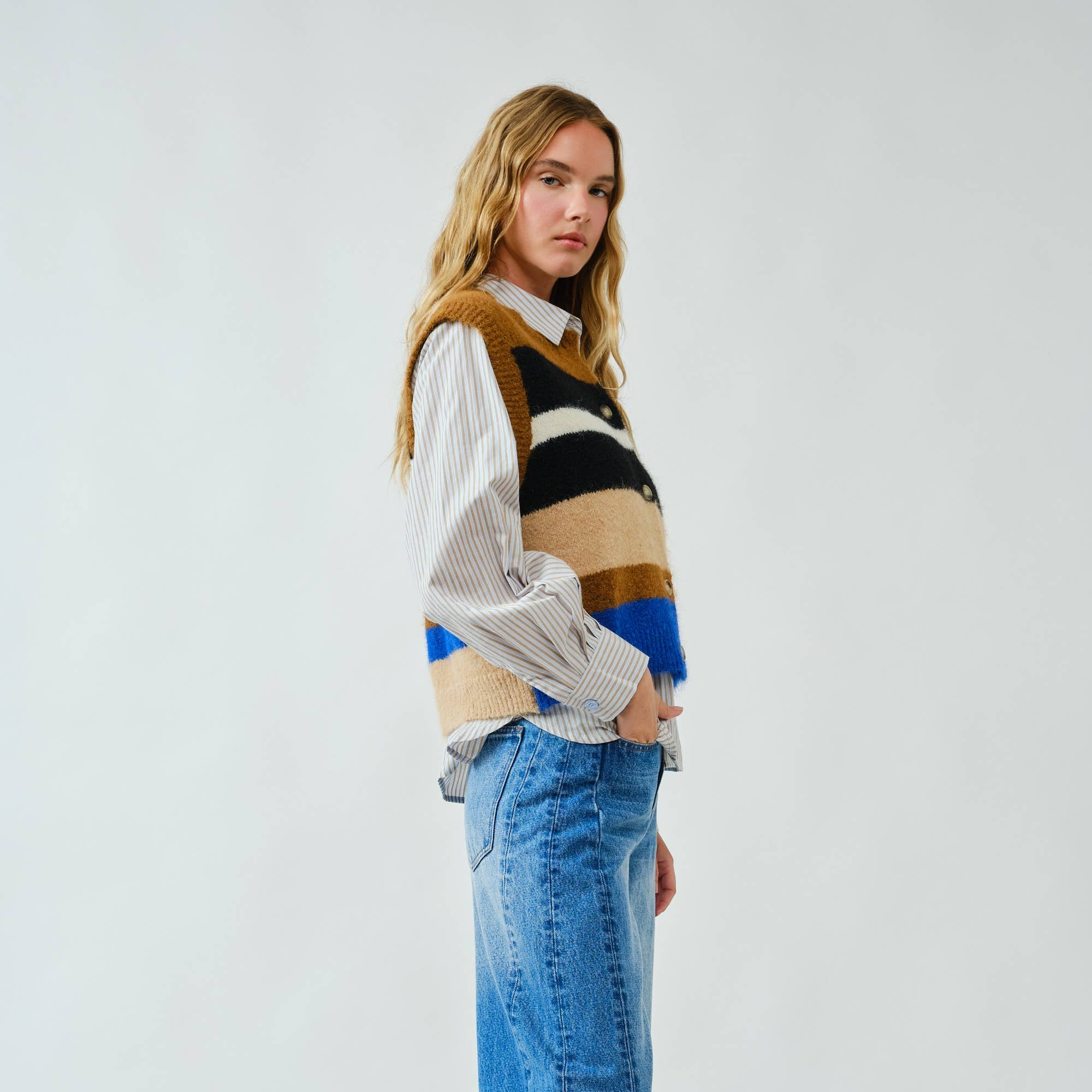 Cozy up in bold style with this soft pullover sweater vest, designed with striking multicolor stripes. The fuzzy knit texture adds warmth, while the relaxed fit and button-down front offer a laid-back, vintage-inspired feel. Whether layered over a shirt or worn on its own, this vest delivers both comfort and standout personality.