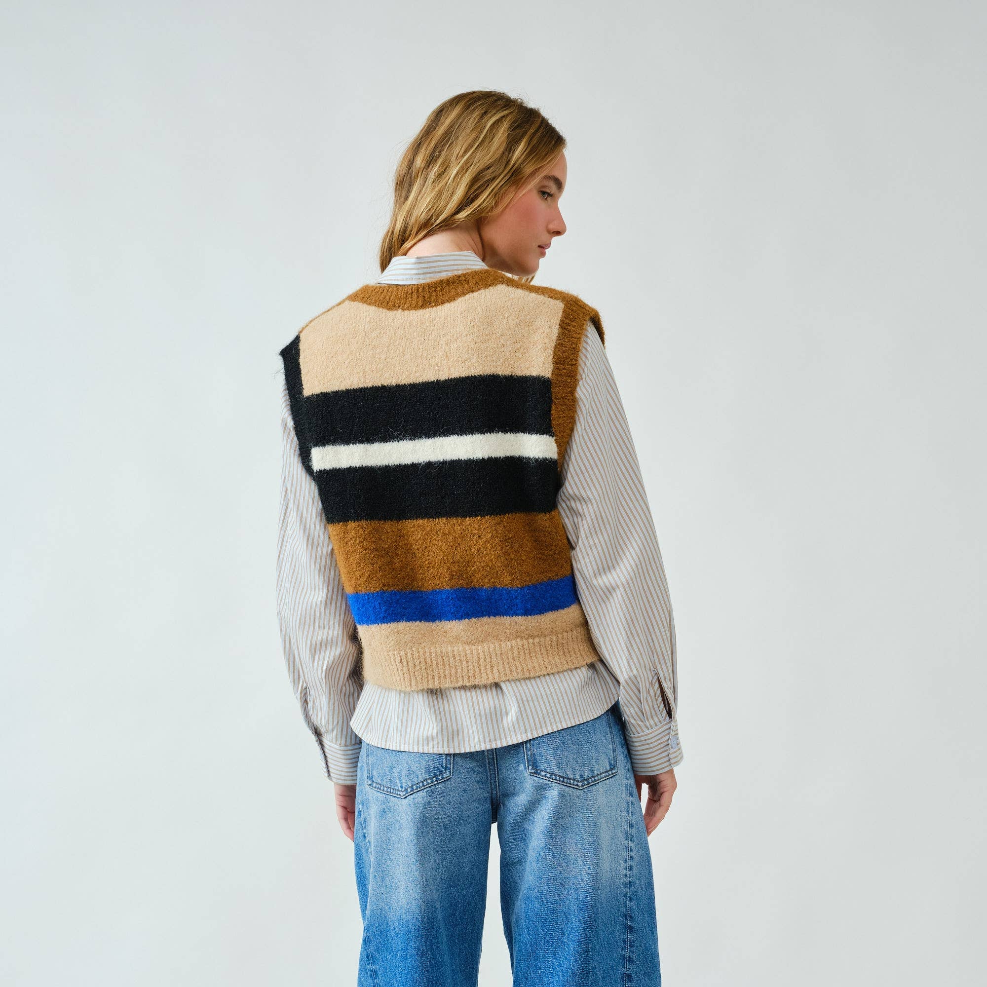 Cozy up in bold style with this soft pullover sweater vest, designed with striking multicolor stripes. The fuzzy knit texture adds warmth, while the relaxed fit and button-down front offer a laid-back, vintage-inspired feel. Whether layered over a shirt or worn on its own, this vest delivers both comfort and standout personality.