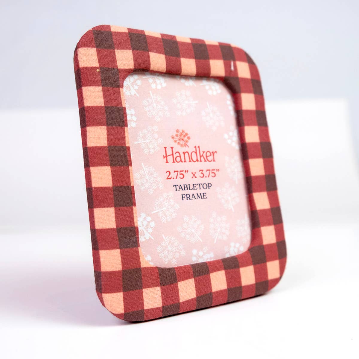 A square tabletop picture frame with a red and beige buffalo plaid border, shown on a clean white background. The center insert is blanked out with a snowflake pattern and text reading 'Handker 2.