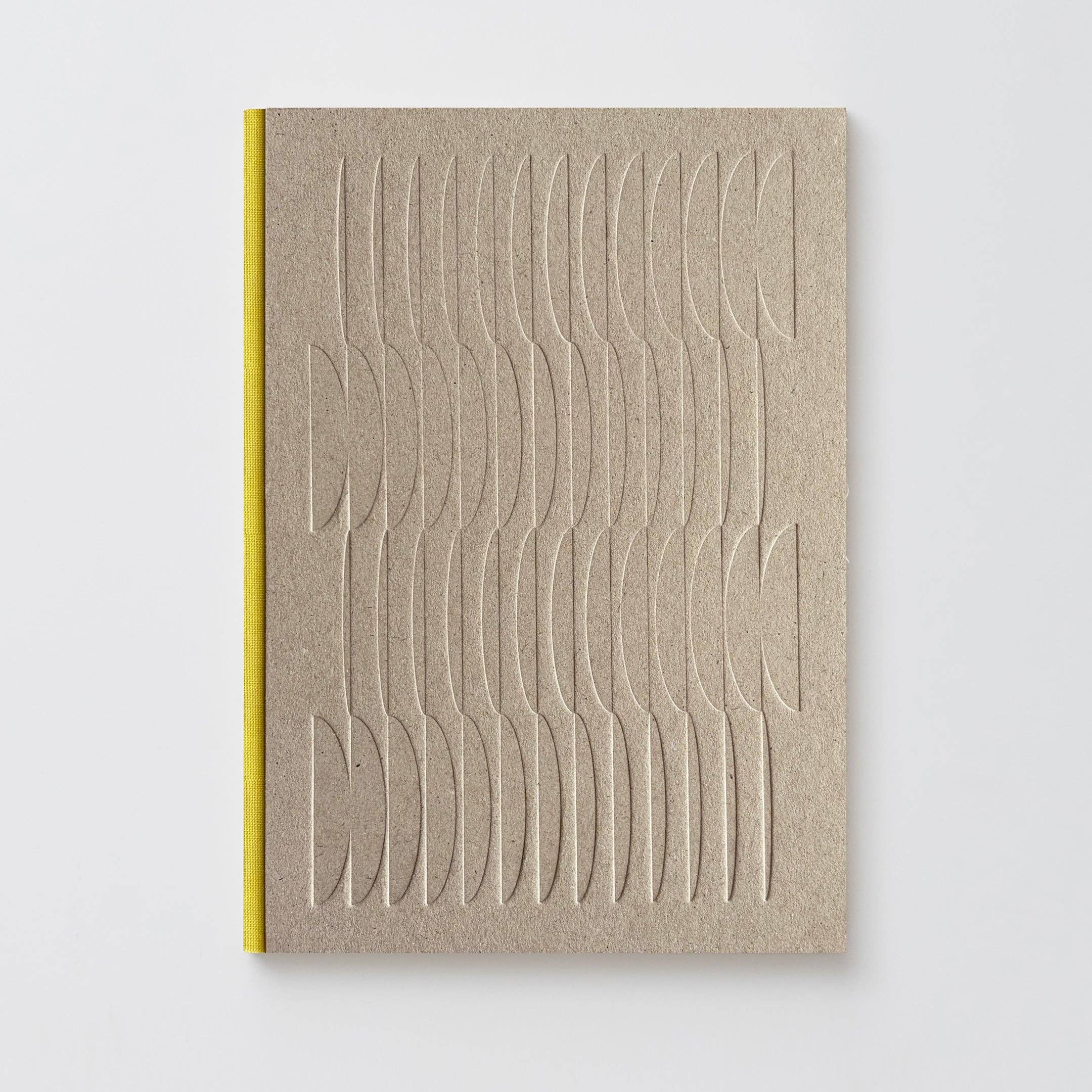 A minimalist notebook with a textured beige cover featuring embossed wavy lines, bound with a bright yellow spine, set against a clean light gray background.