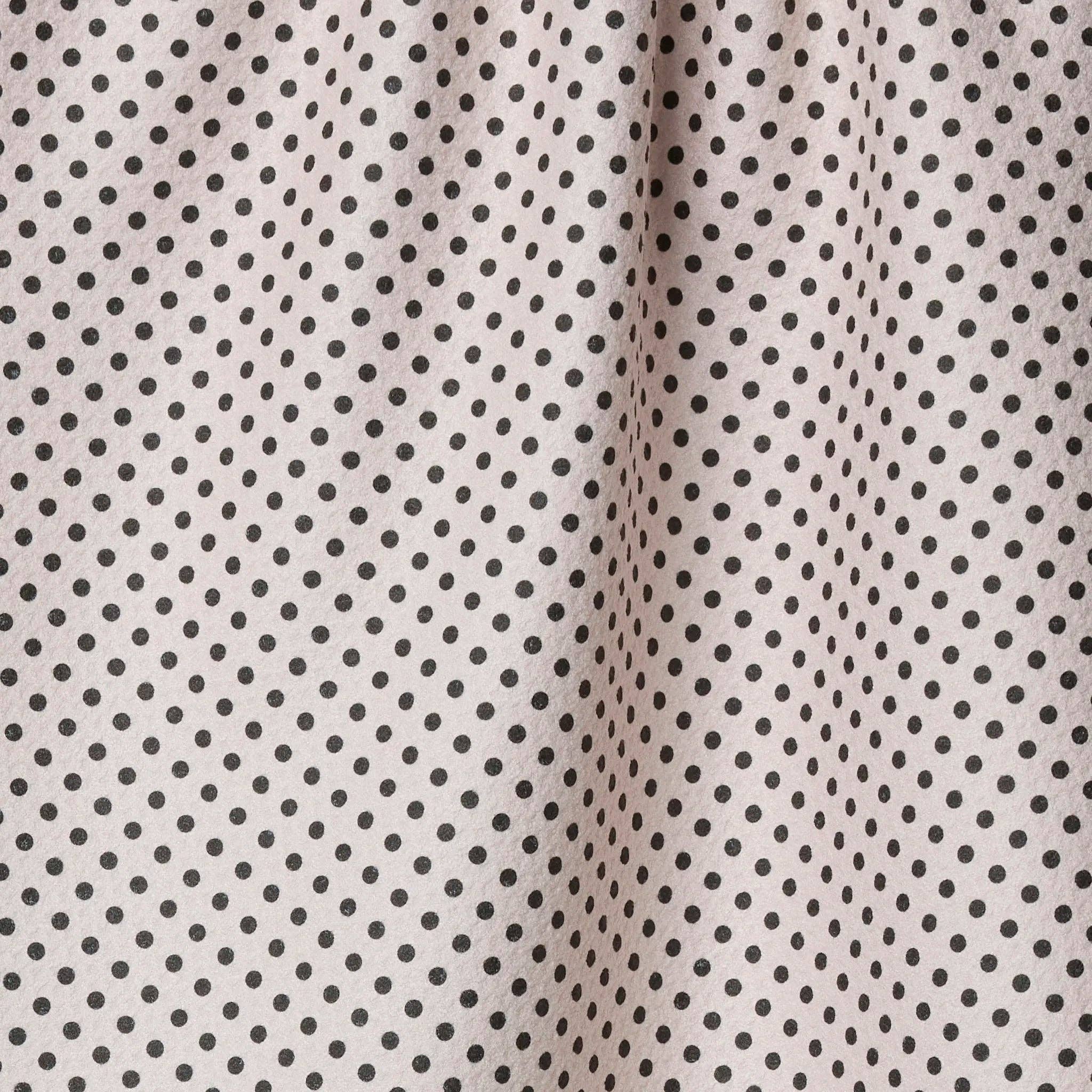 Close-up of ftea towel with small black polka dots on a beige background