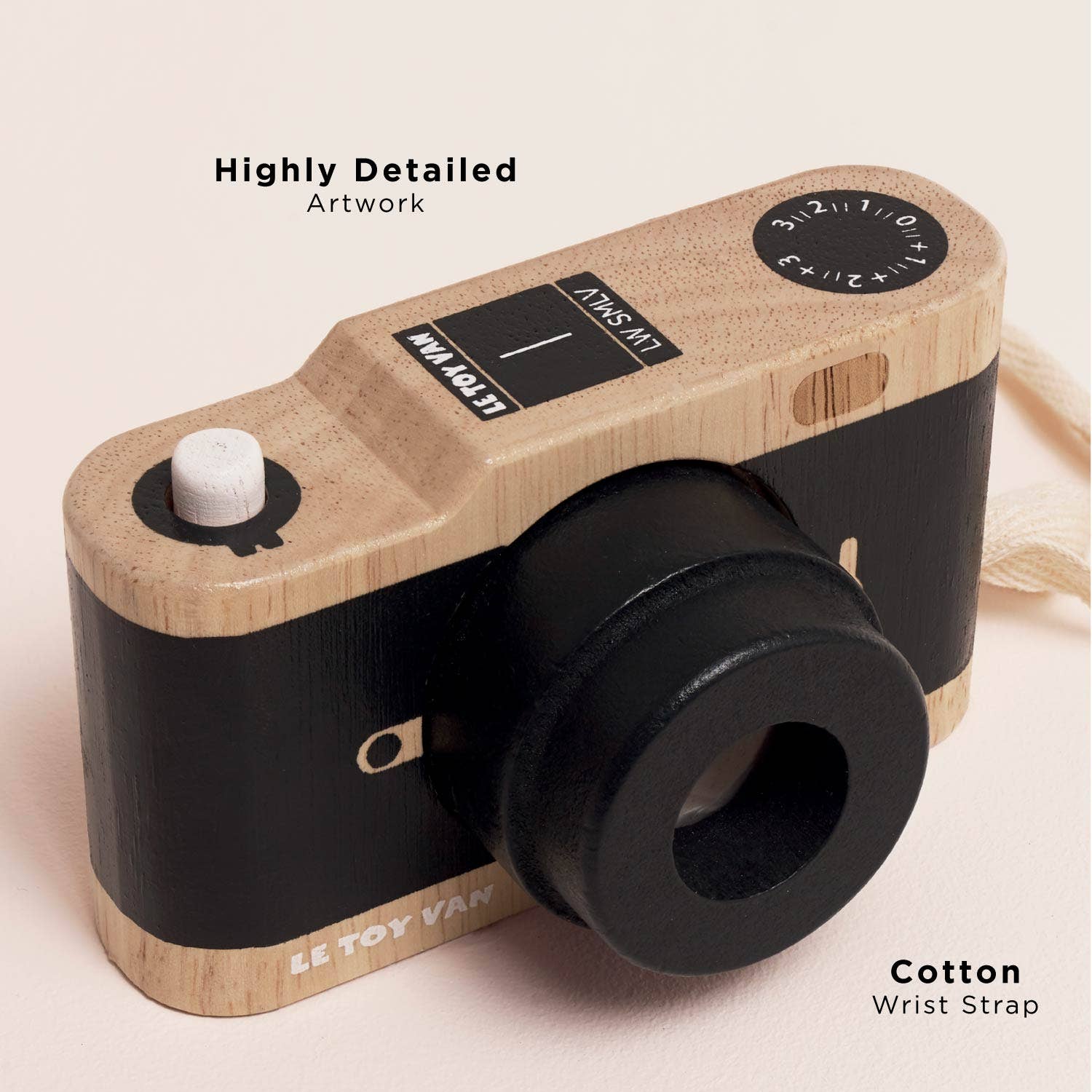Toy camera with wooden and black design on a light pink background