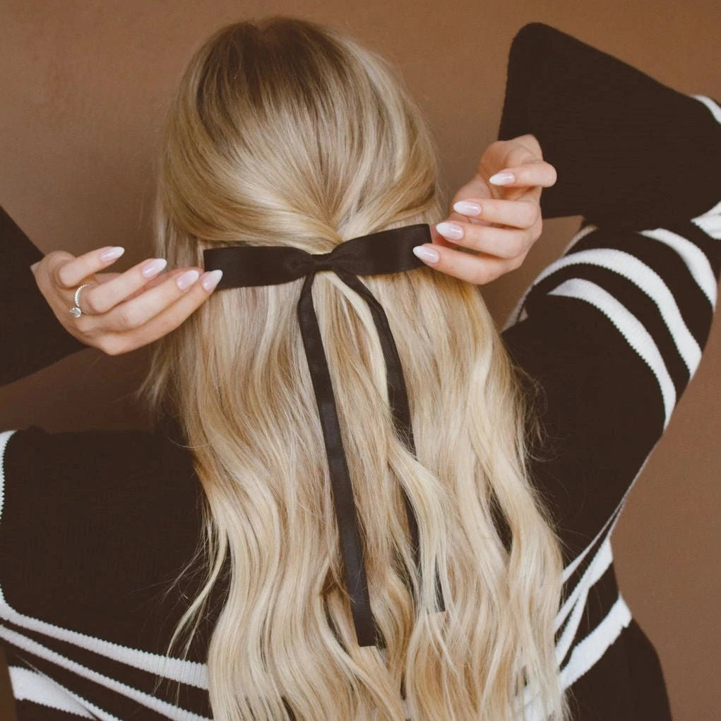 Introducing our Black Satin Ribbon Long Bow Clip! Featuring extra long tails and a secure alligator clip, this bow is perfect for adding a touch of elegance to any outfit. Plus, its neutral black color is versatile and will match any style. Get ready to make a statement (with style) wearing this bow!