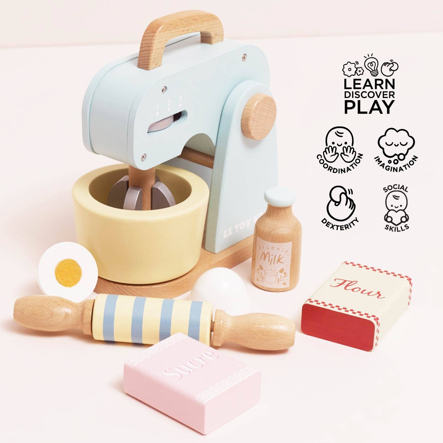 Children's toy kitchen set with pastel colors on a light pink background